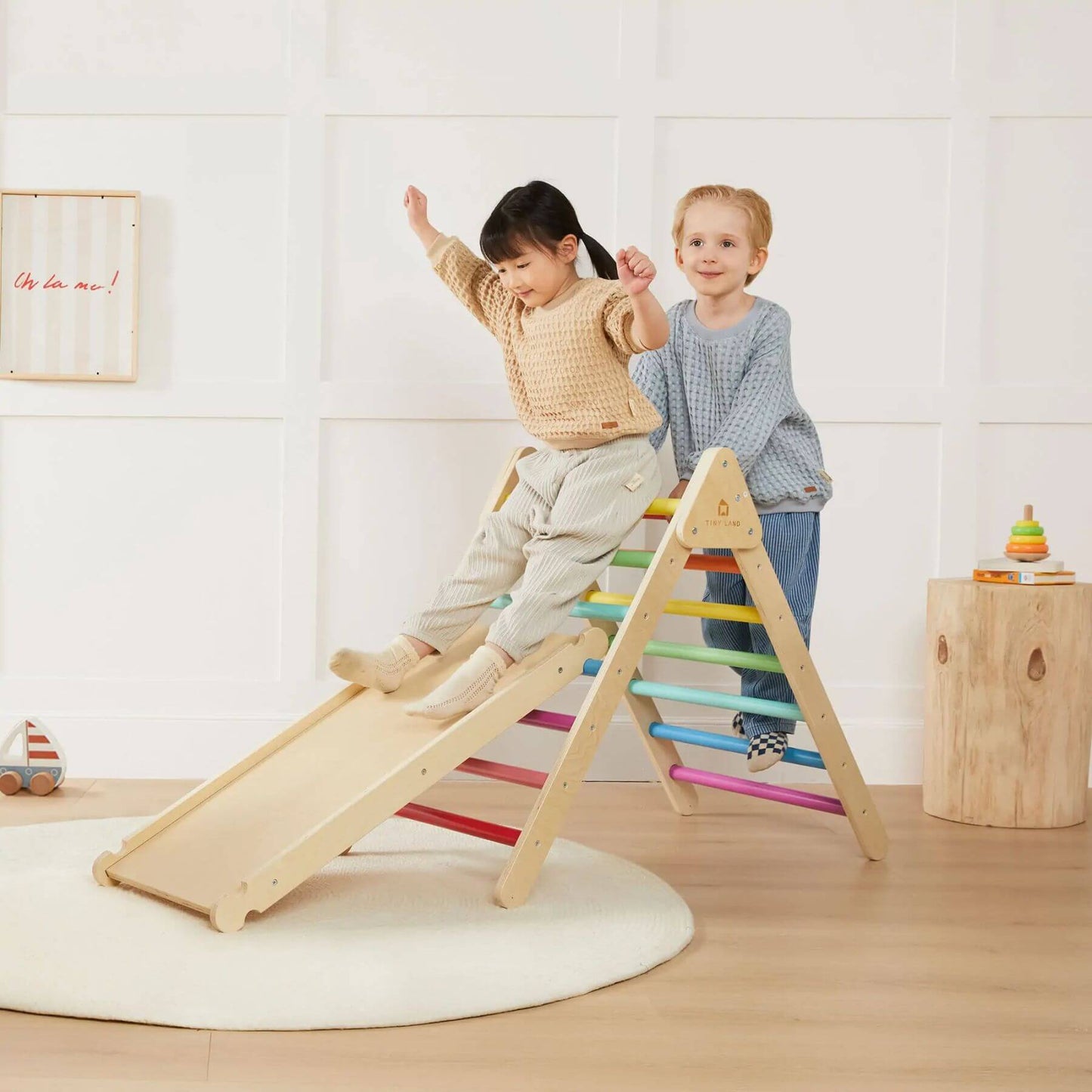 Two children playing on Tiny Land® 7-in-1 Rainbow Climbing Set with Play Pad indoors.
