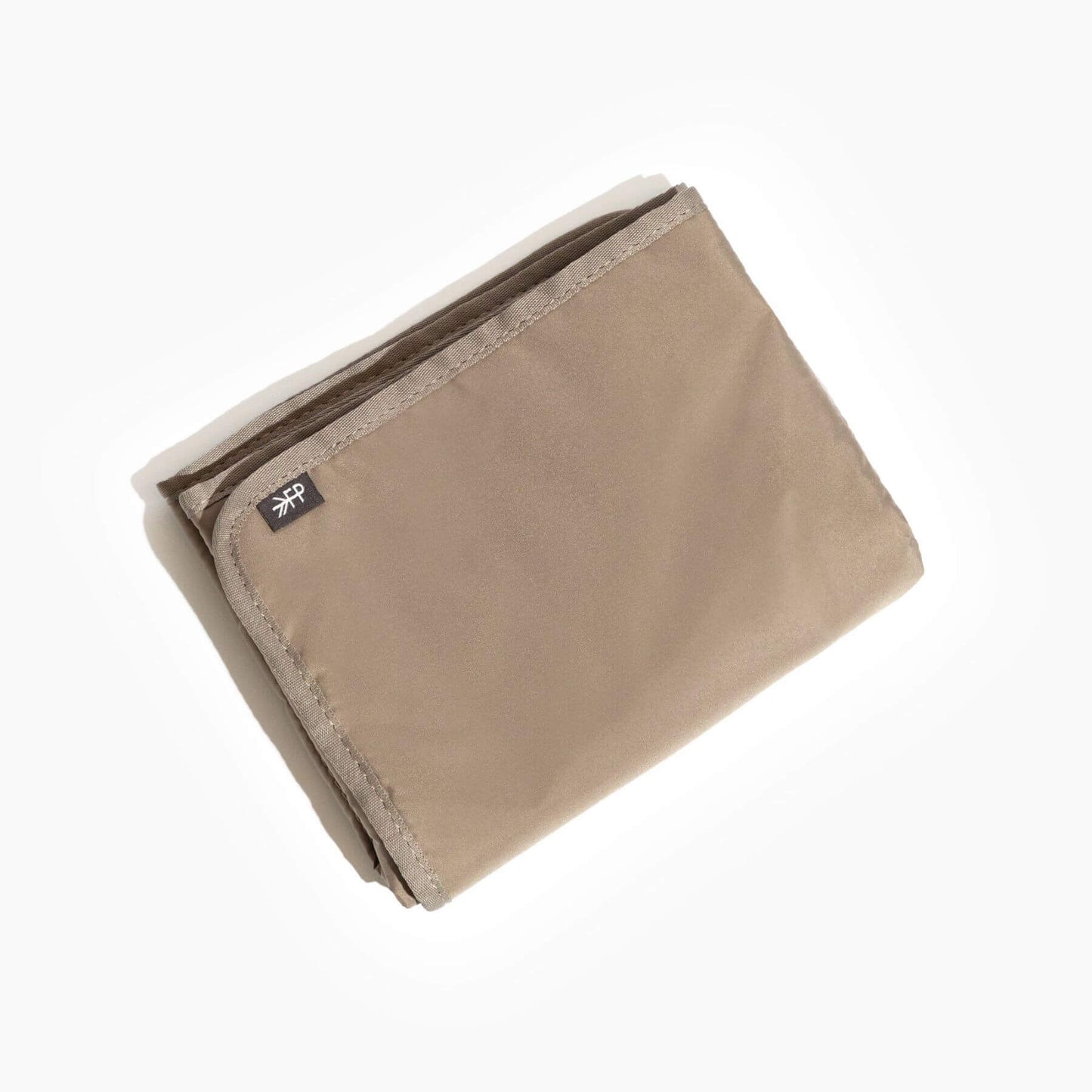 Beige blanket with a brand label on a white background