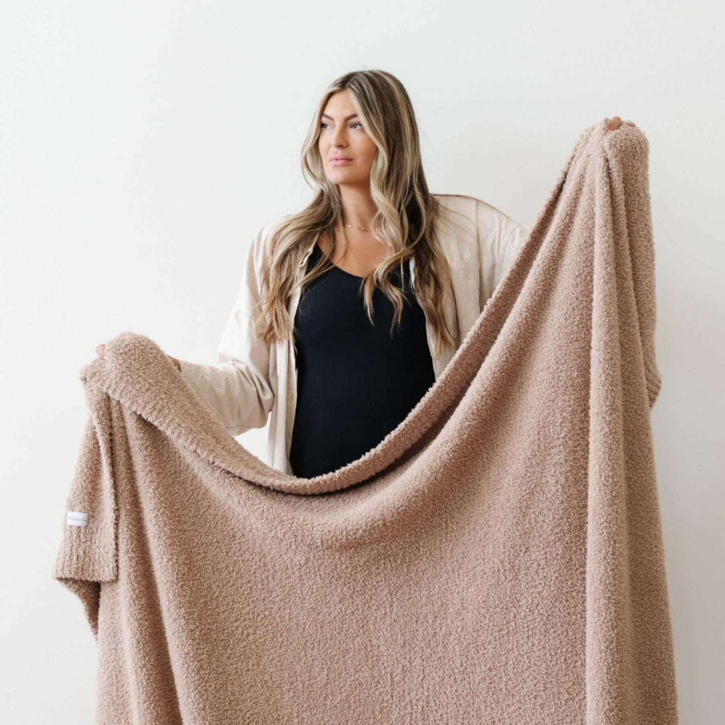 Woman holding Saranoni Bamboni® Throw Blanket against a white background