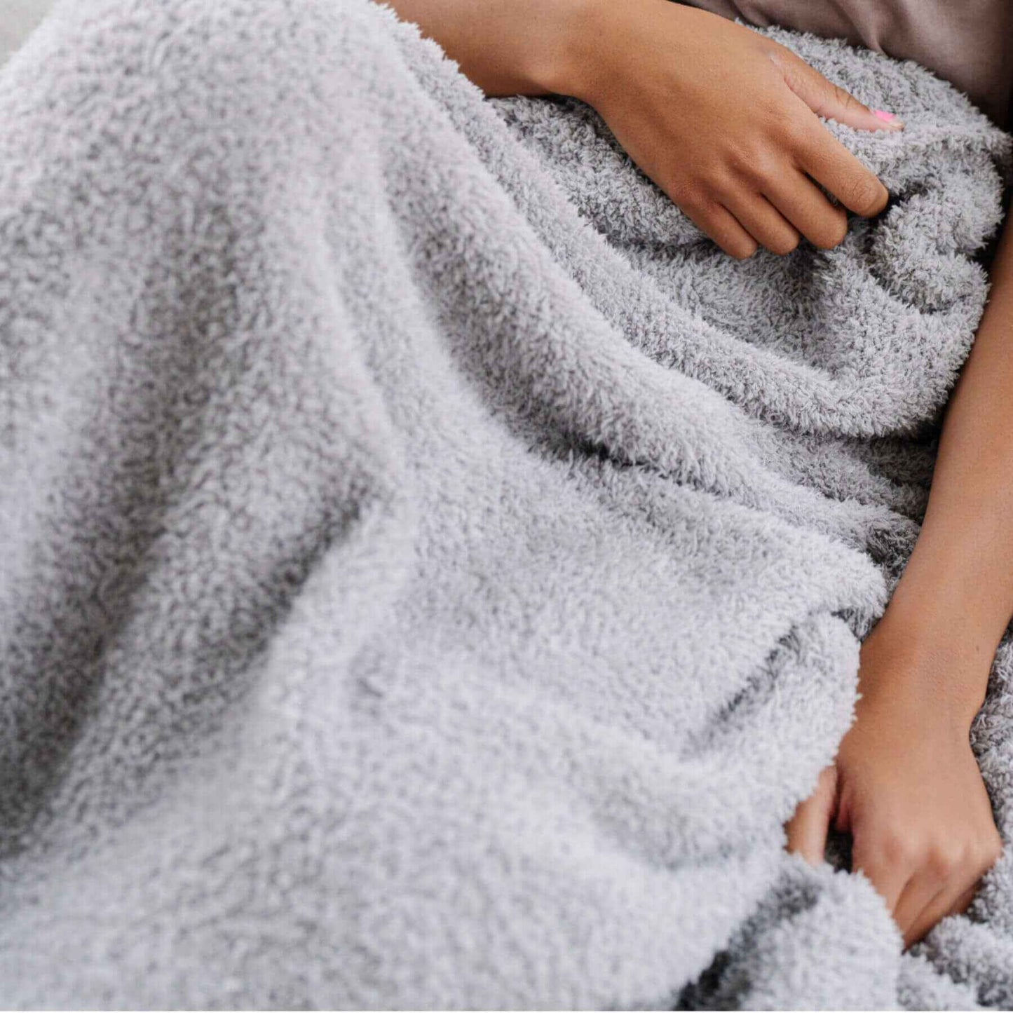Person wrapped in Saranoni Bamboni® Throw Blanket with hands visible