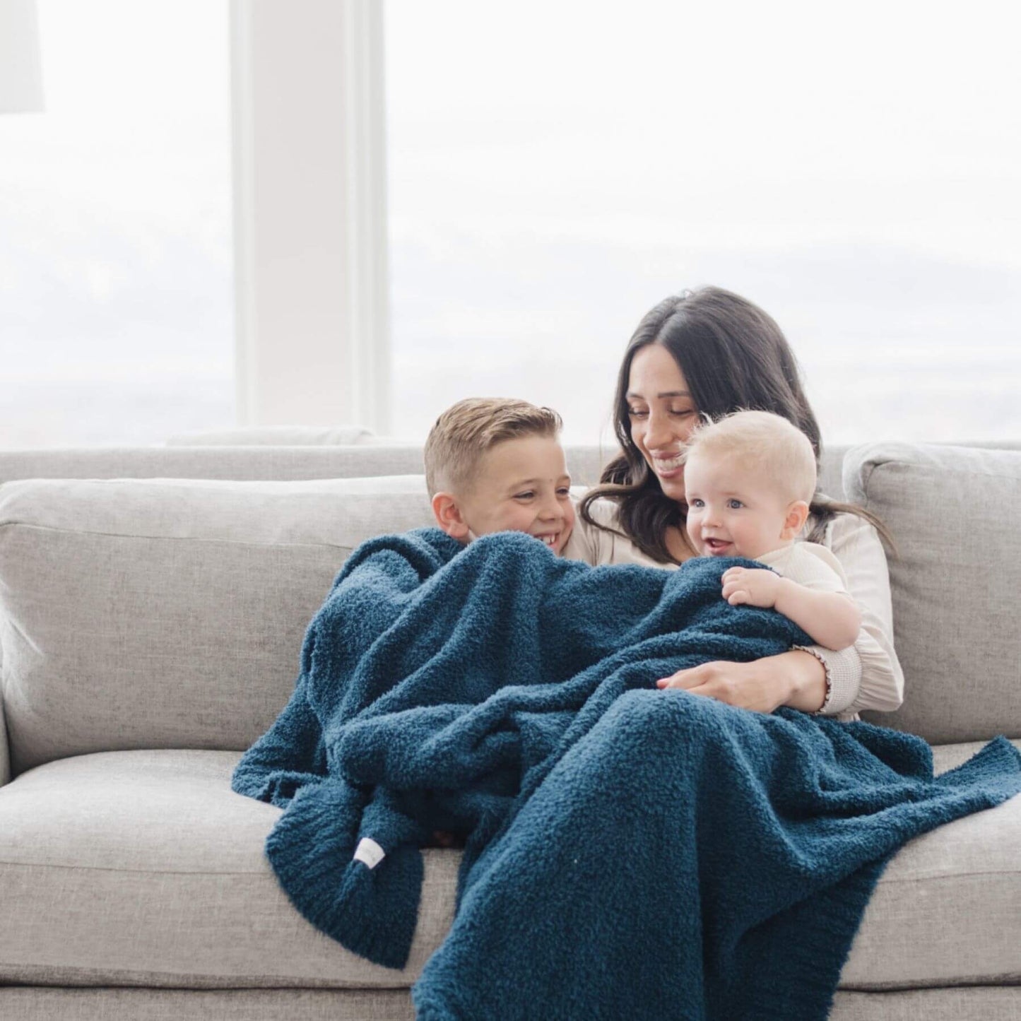 Woman and two children on a couch with Saranoni Bamboni® Throw Blanket