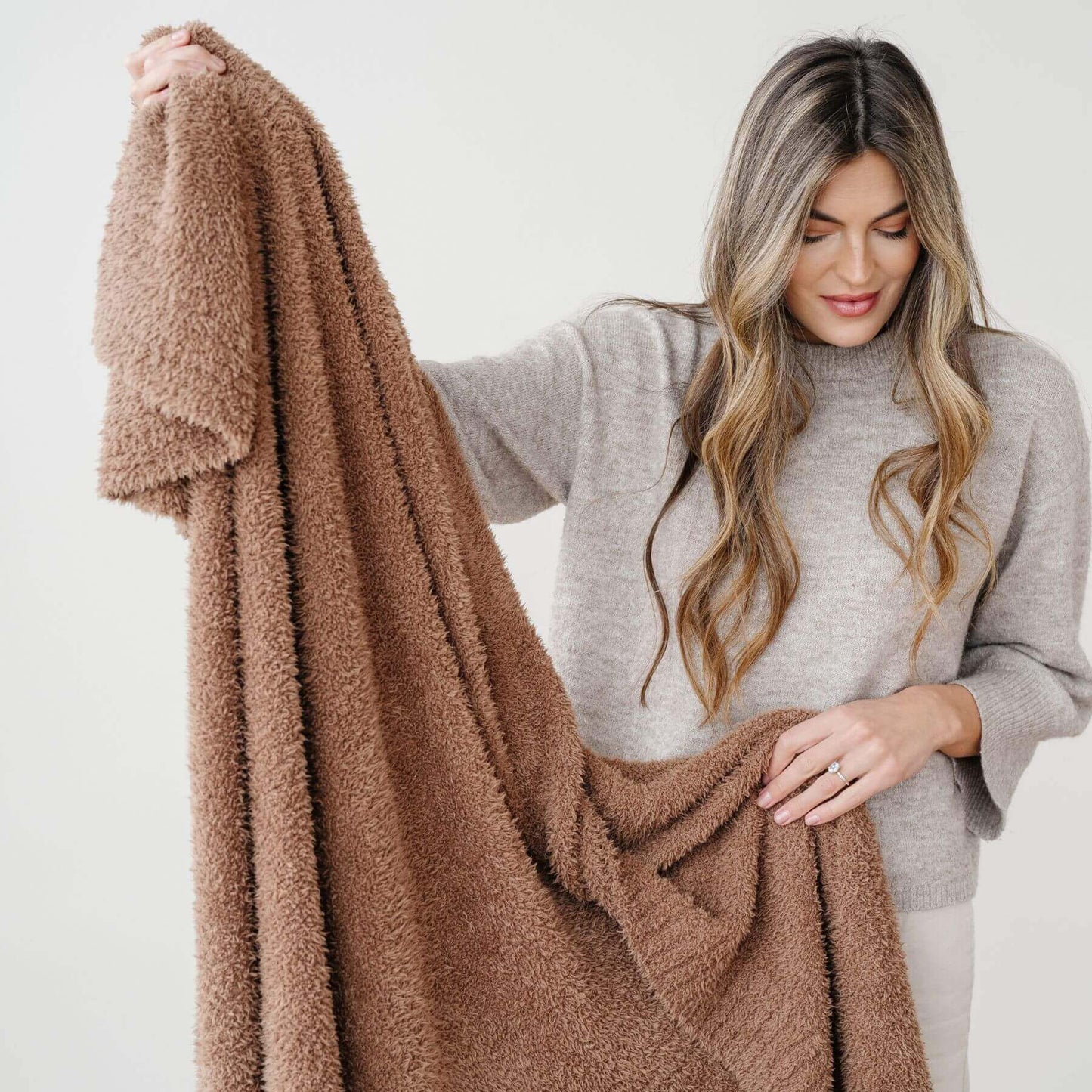 Woman holding Saranoni Bamboni® Throw Blanket against a white background