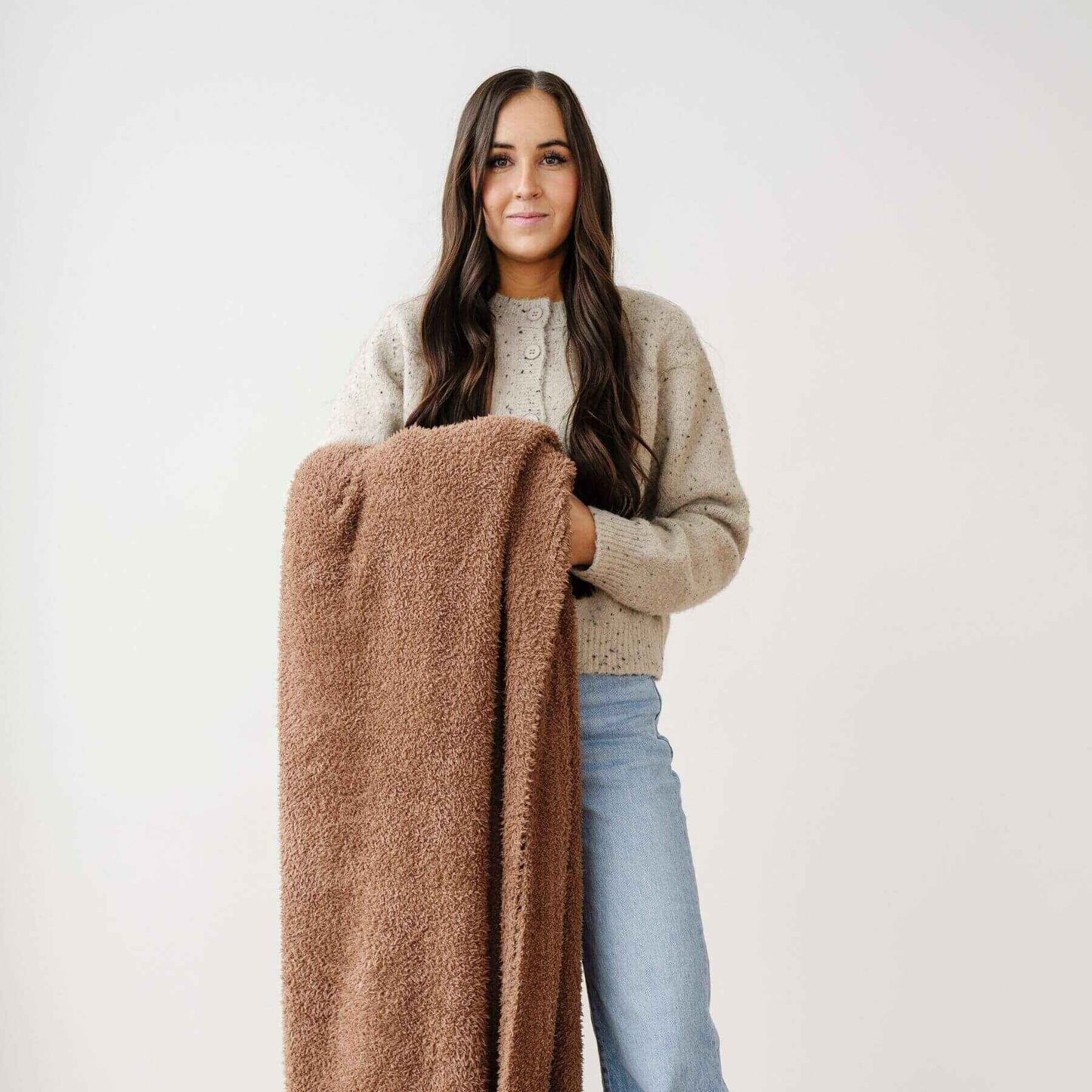 Woman holding Saranoni Bamboni® Throw Blanket against a white background