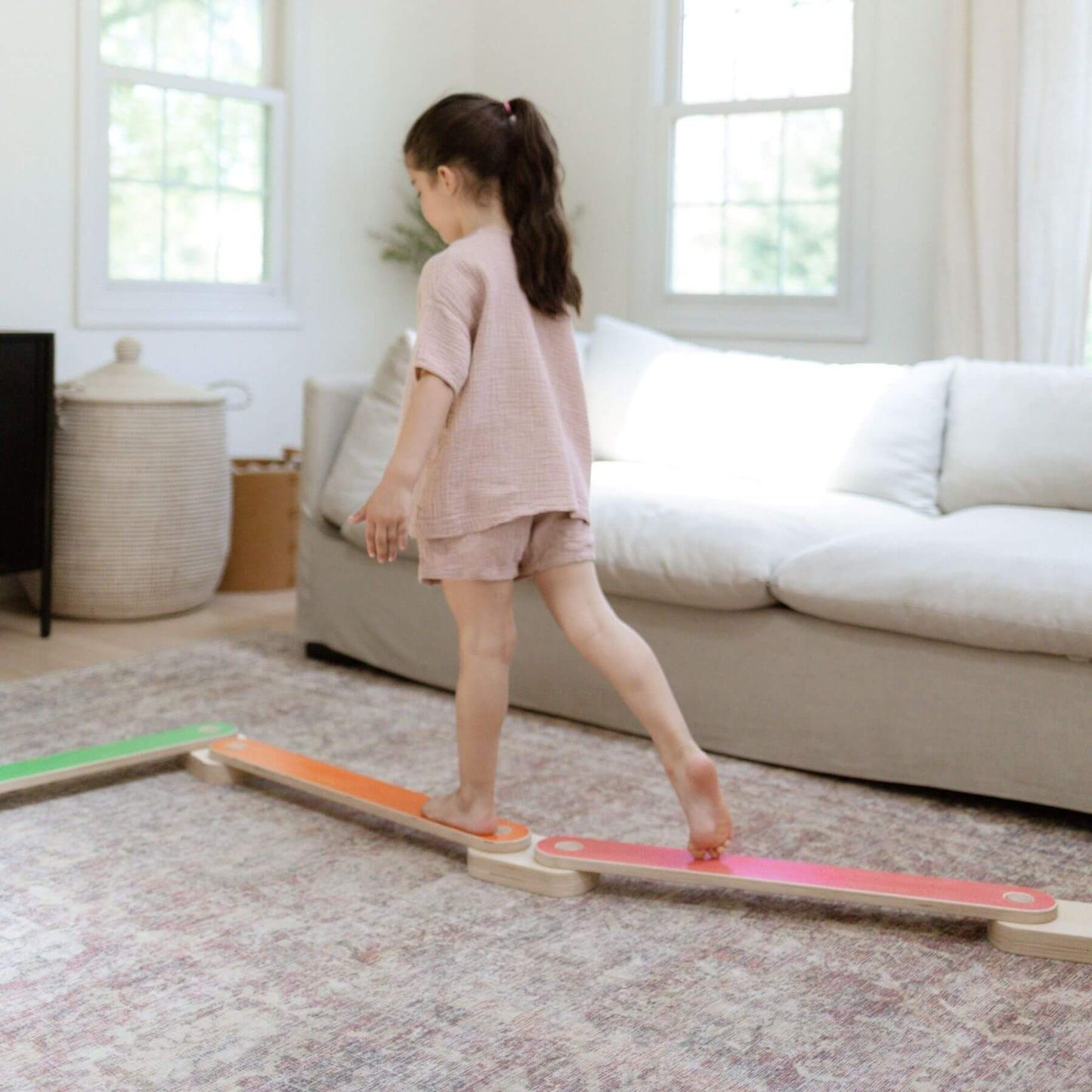 Child standing on Bunny Hopkins Balance Beam in a living room