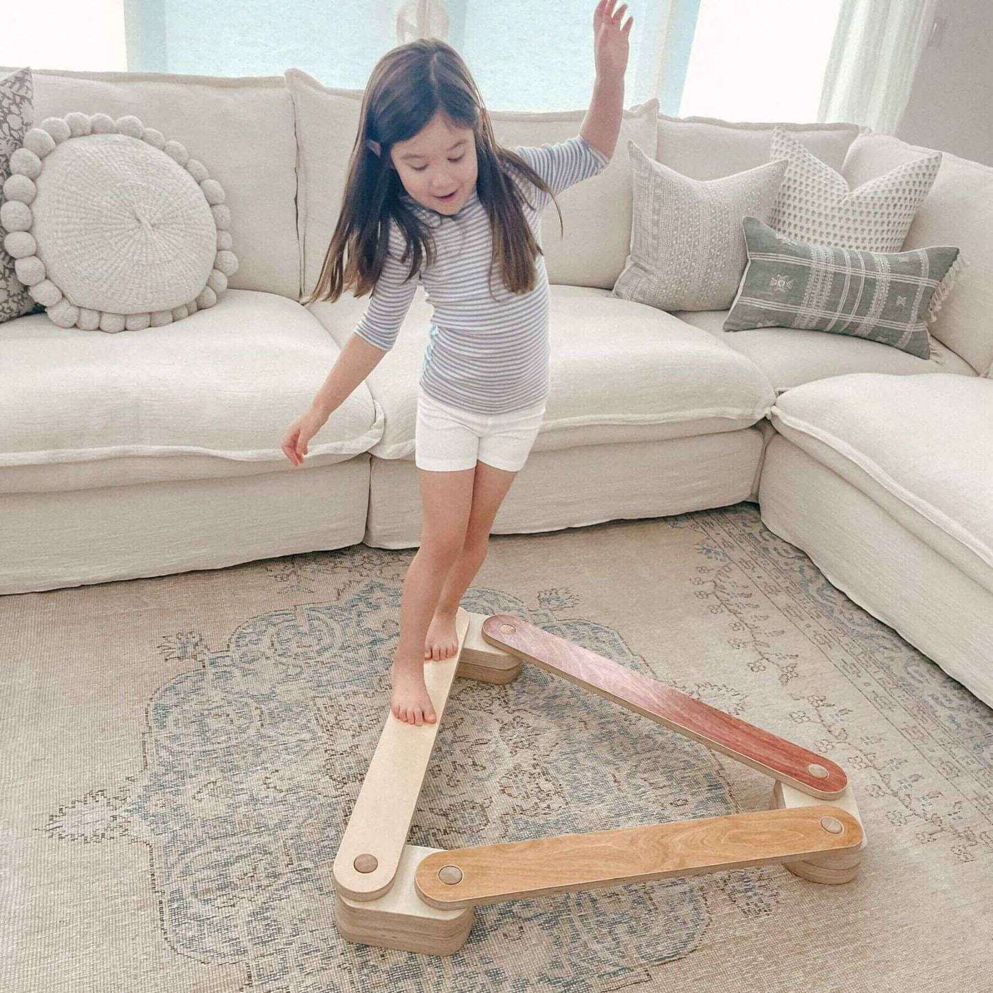 Child playing with Bunny Hopkins Balance Beam in a living room.