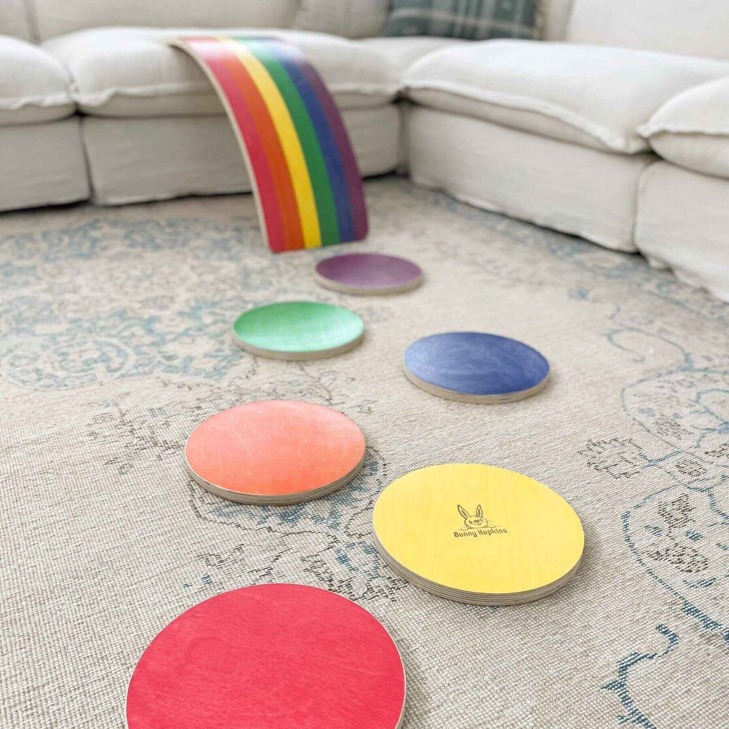 Bunny Hopkins Stepping Stones on a textured rug with a rainbow item in the background.