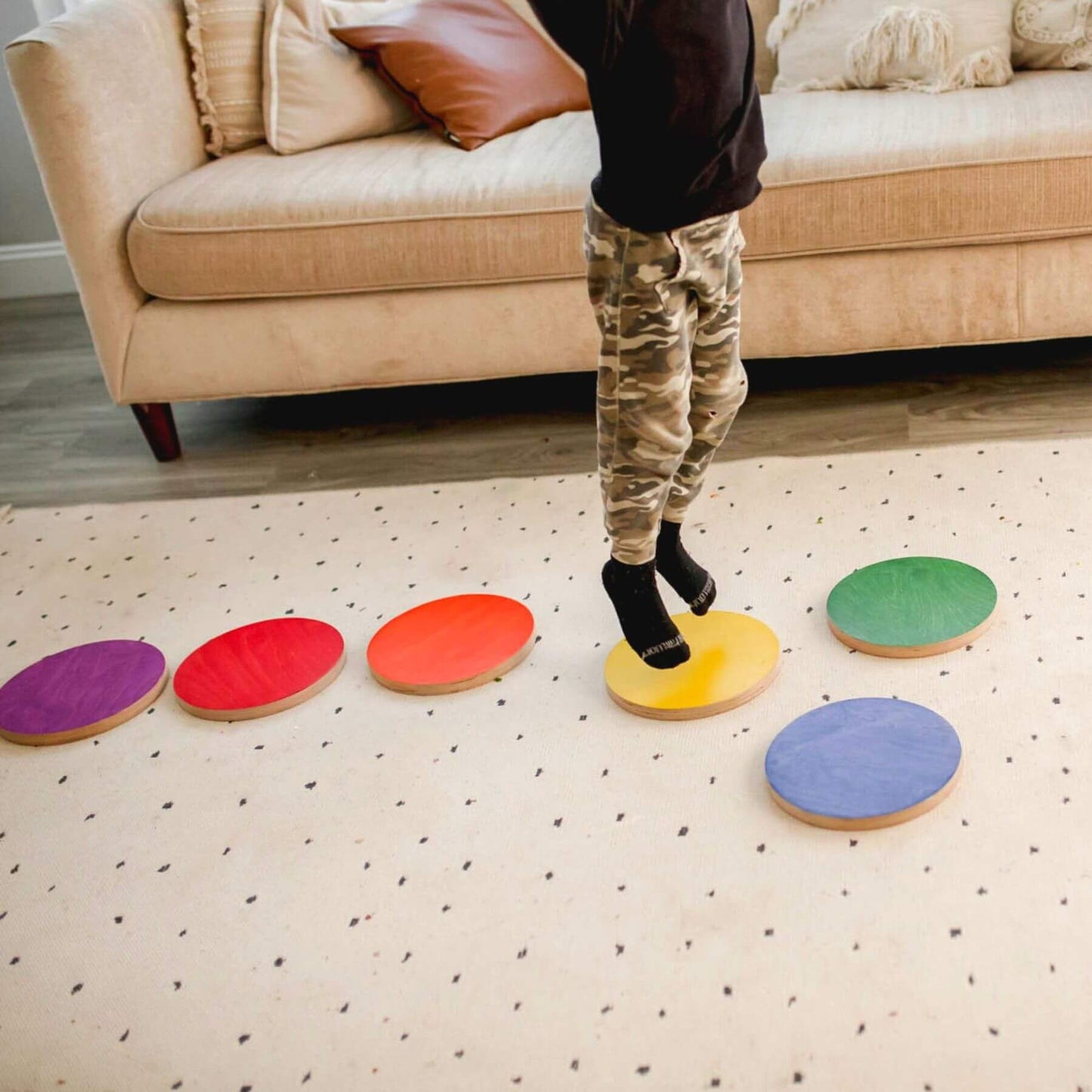 Person stepping on Bunny Hopkins Stepping Stones on a patterned rug.