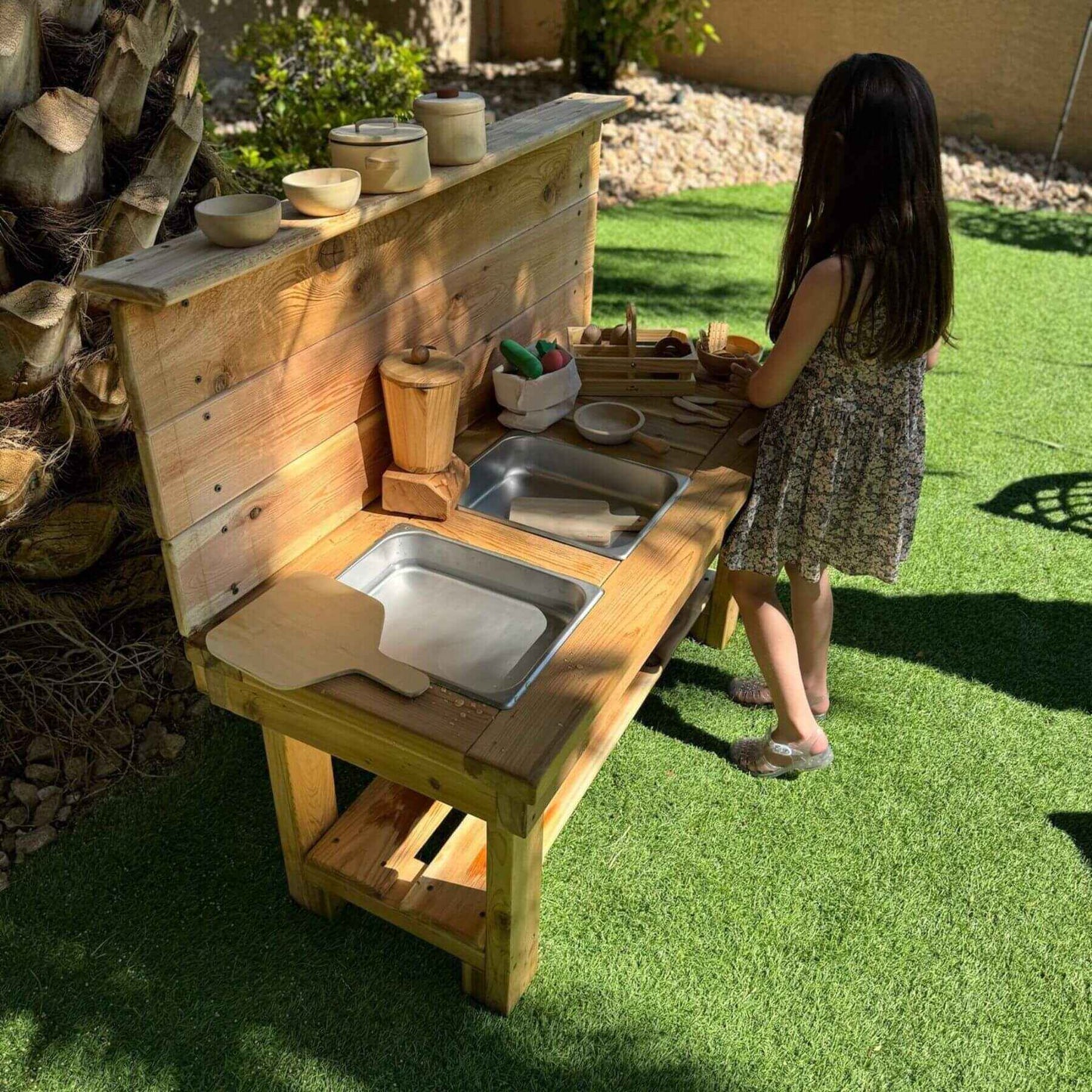 Child playing with Bunny Hopkins Mud Kitchen on grass