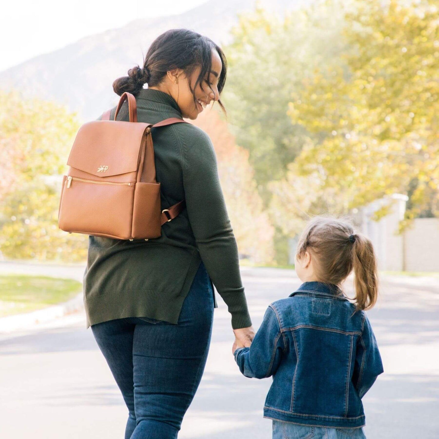 Woman with Butterscotch Mini Classic Bag II and a child holding hands outdoors
