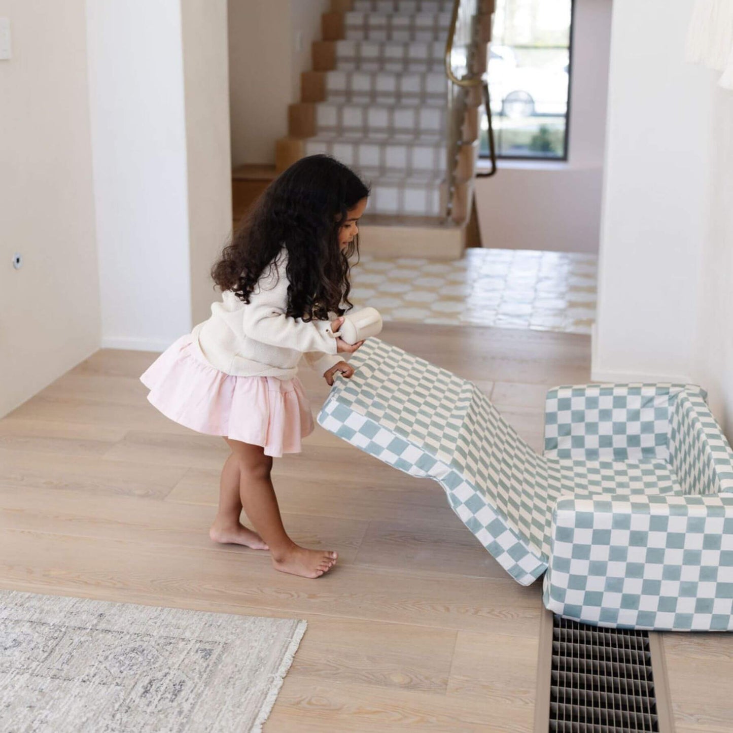 Child playing with Toki Kids Checker Matcha Play Couch on a wooden floor