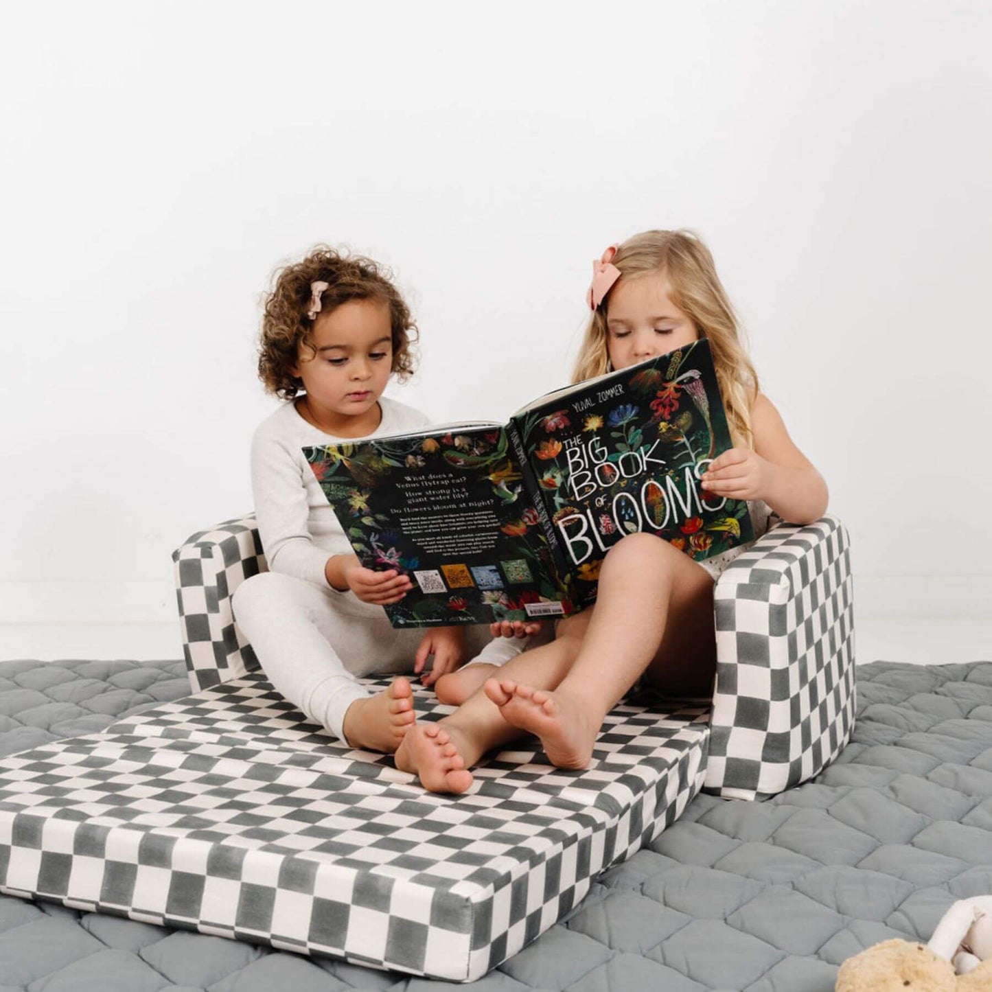 Two children sitting on Toki Kids Checker Pepper Play Couch reading a book together.
