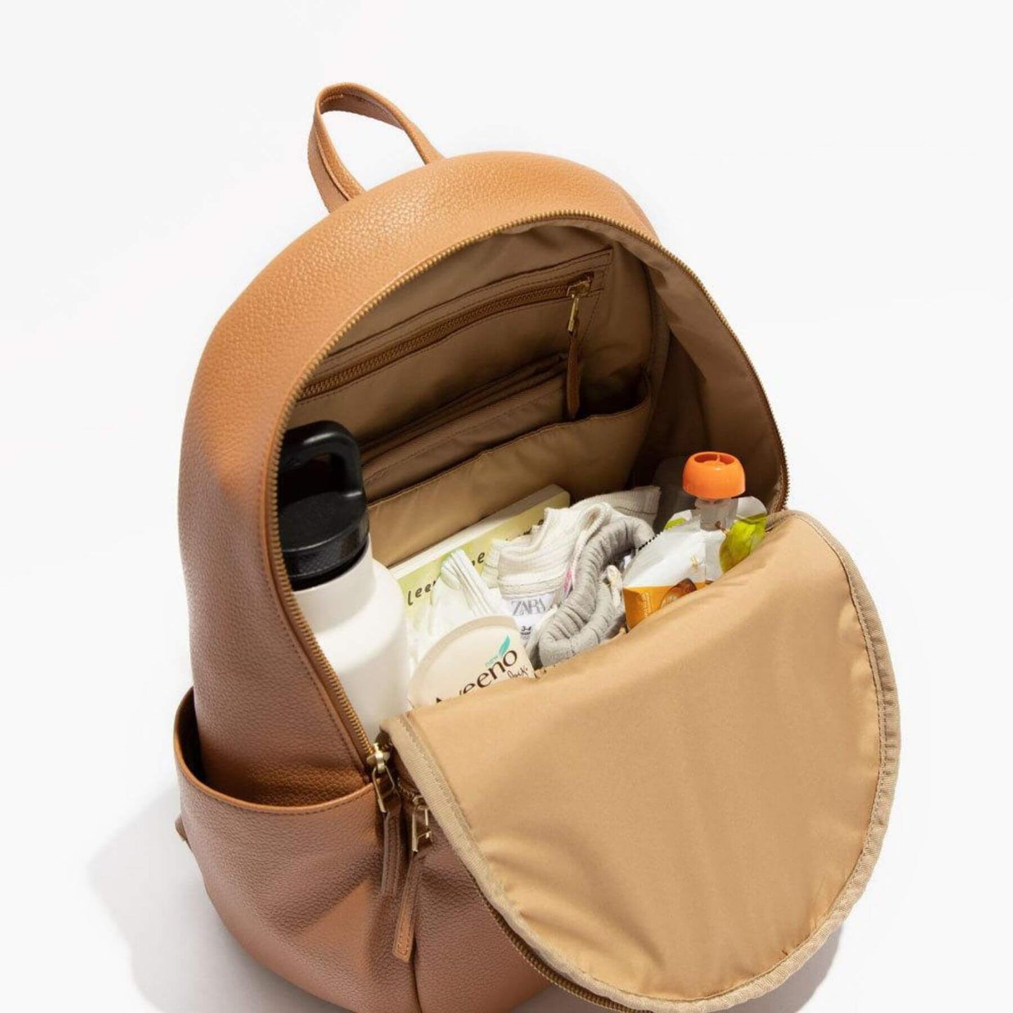 Open brown leather backpack with items inside on a white background