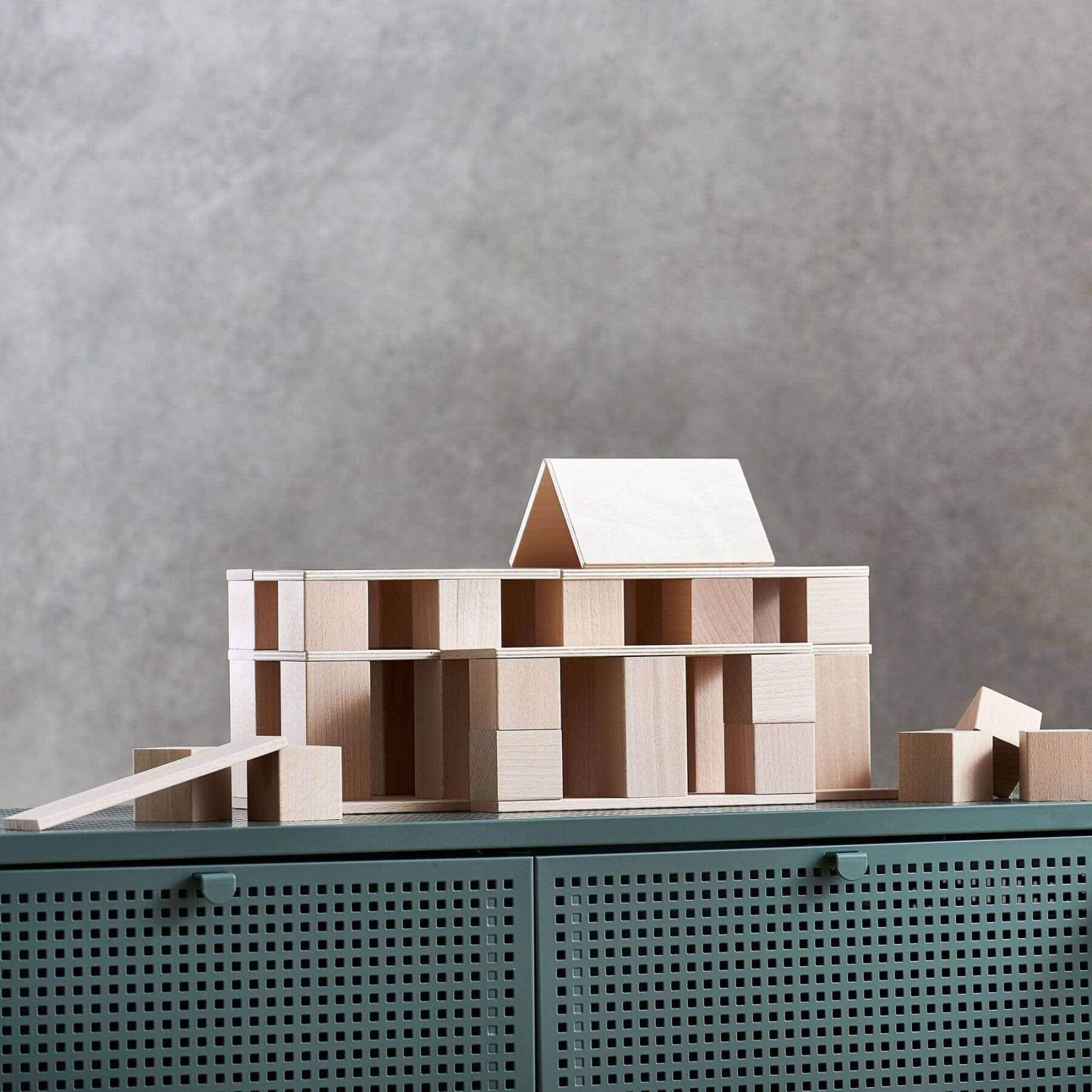 HABA USA Clever Up! Building Block System 2.0 on a green surface with a gray background