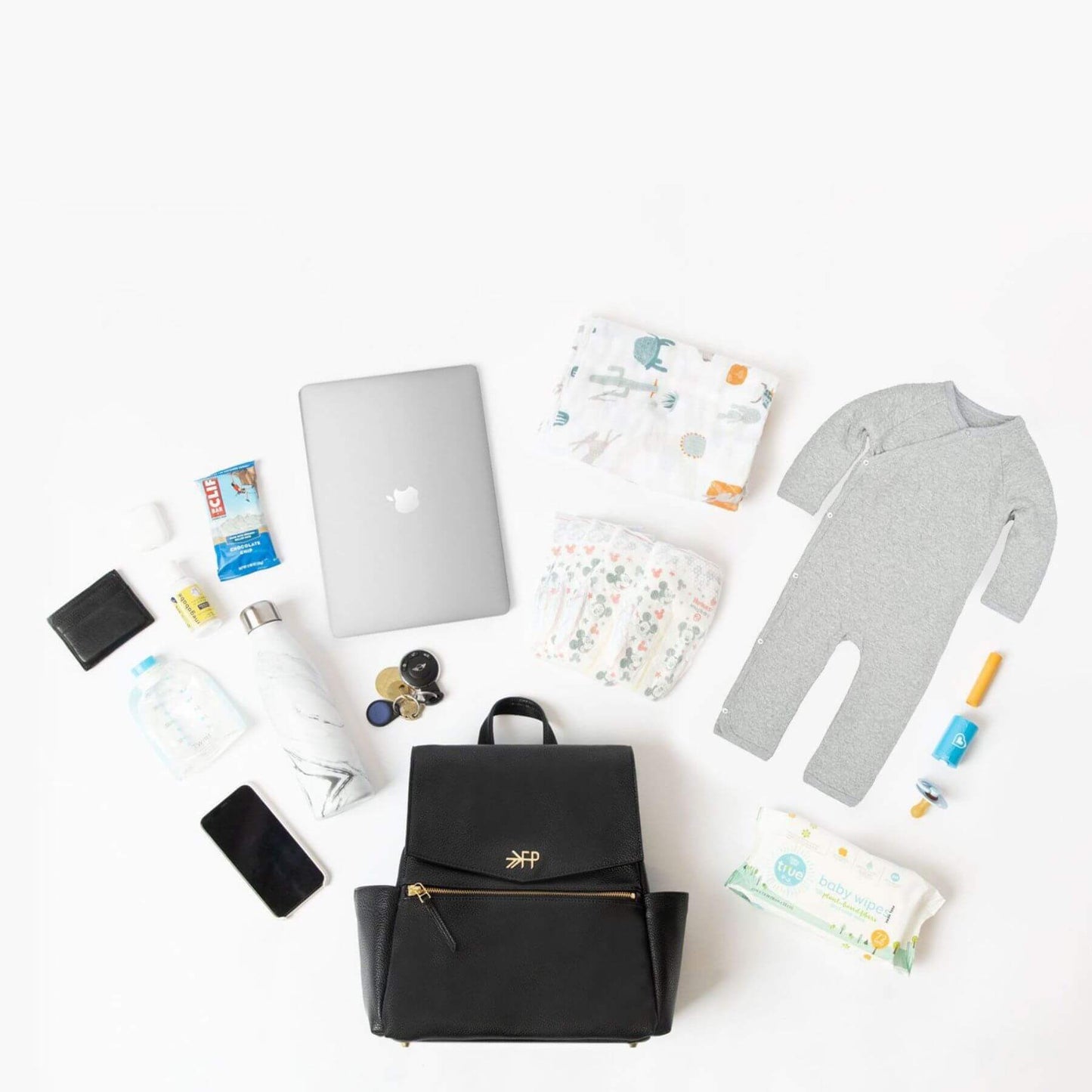 Collection of baby items including a black backpack, diaper, and baby clothes on a white background