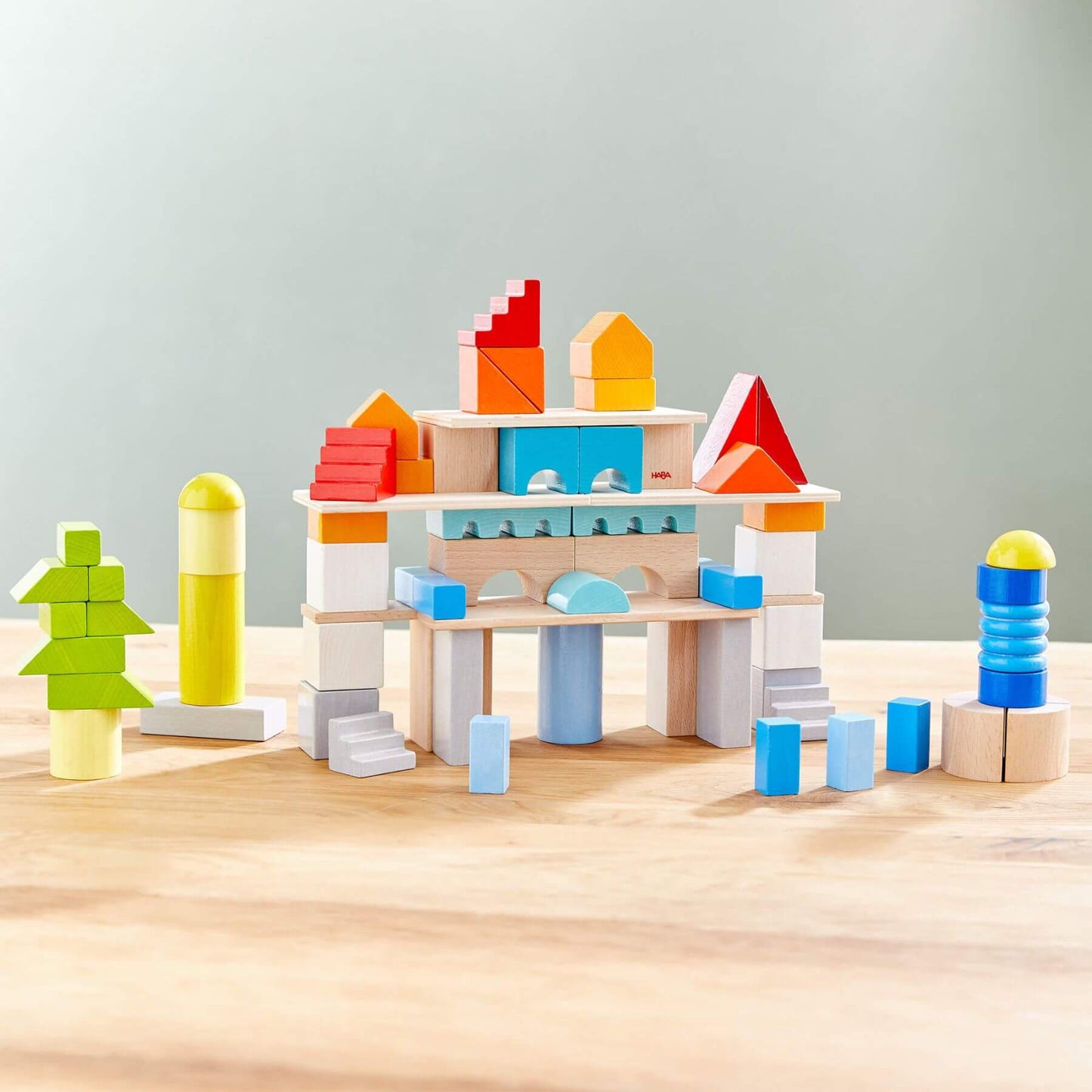 HABA USA Colored Wooden Building Blocks - 85 Piece Seton a wooden surface with a light gray background