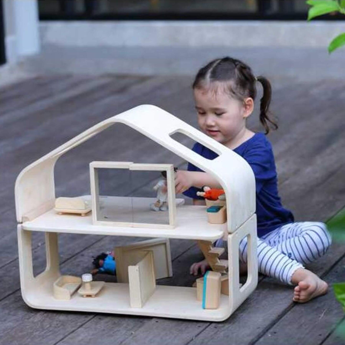 Girl Playing PlanToys Contemporary Dollhouse