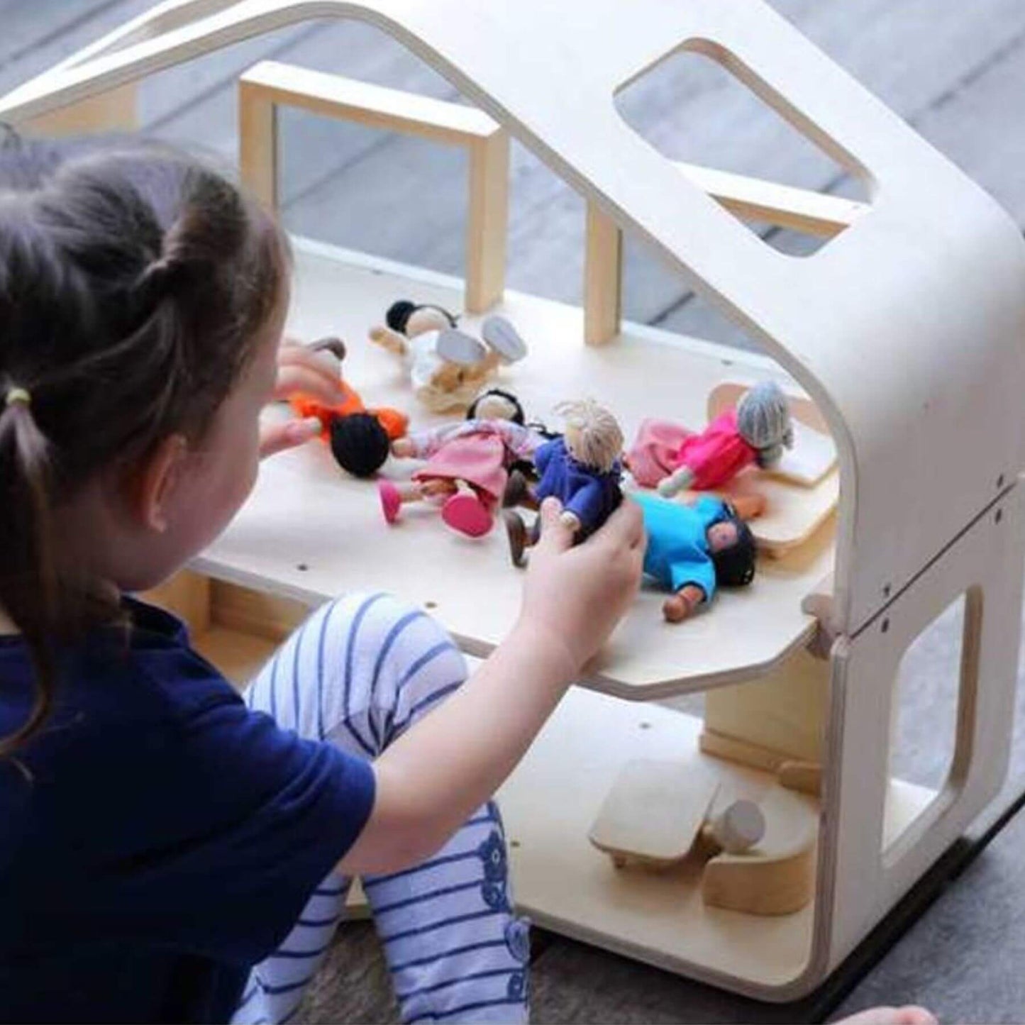 Girl Playing PlanToys Contemporary Dollhouse