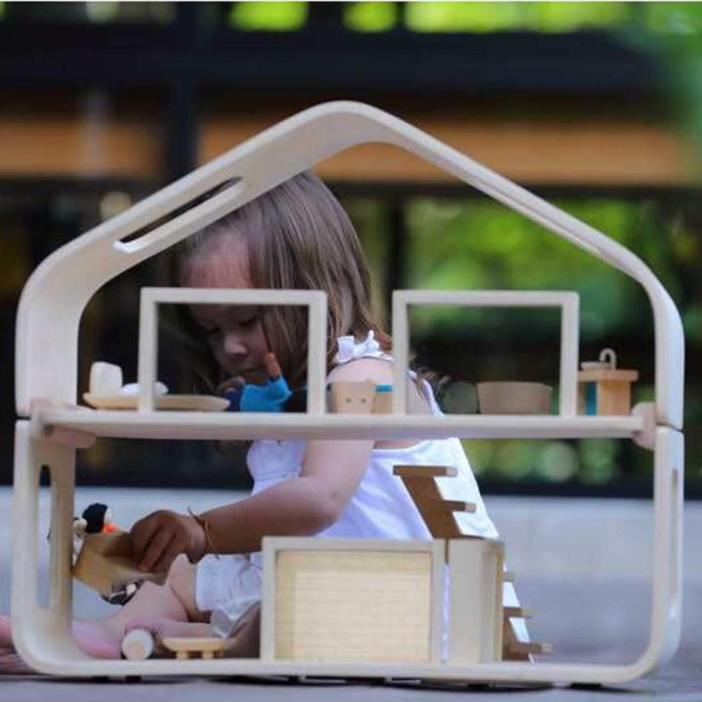 Girl Playing PlanToys Contemporary Dollhouse