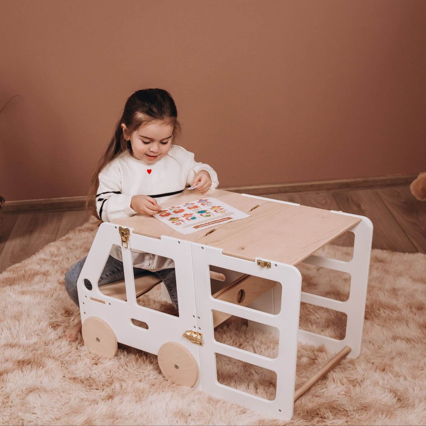 Girl Sitting at Wood and Hearts Convertible Kitchen Tower Truck White & Wood