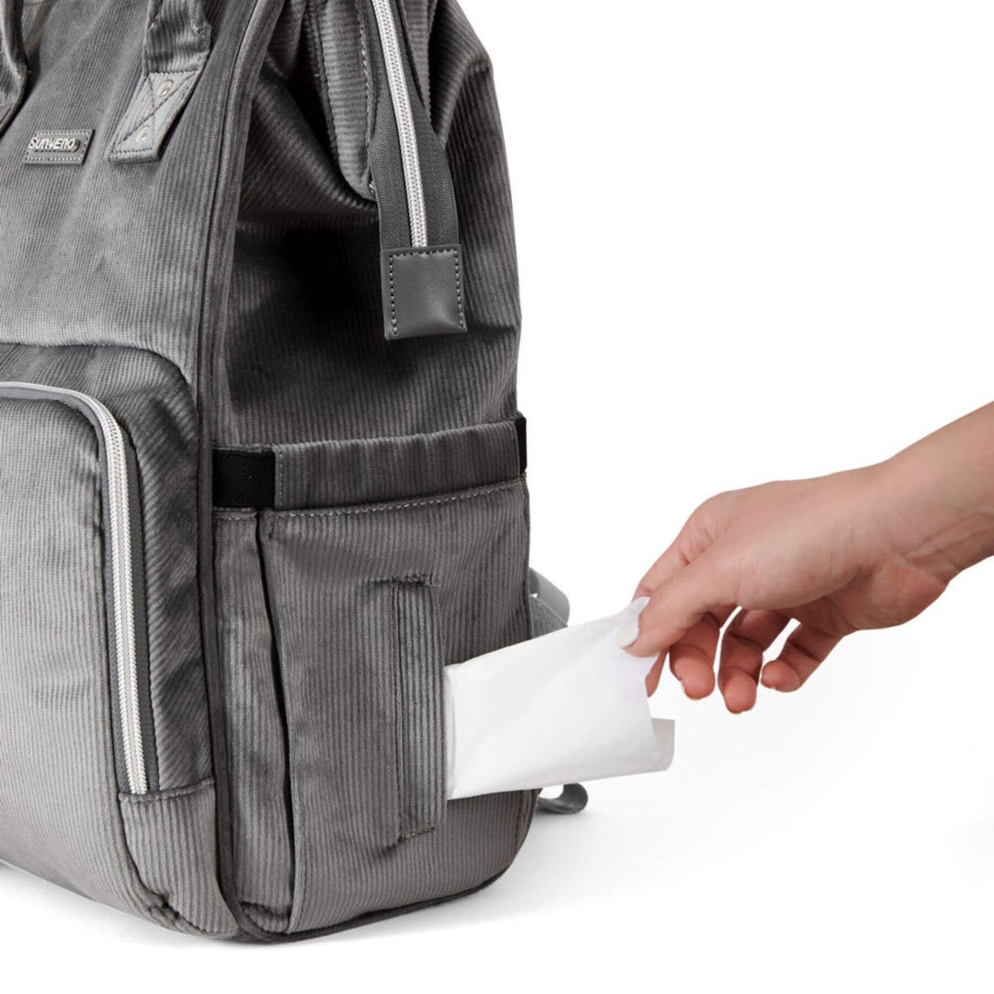 Corduroy Diaper Backpack Grey with a hand placing a white pouch into one of its pockets