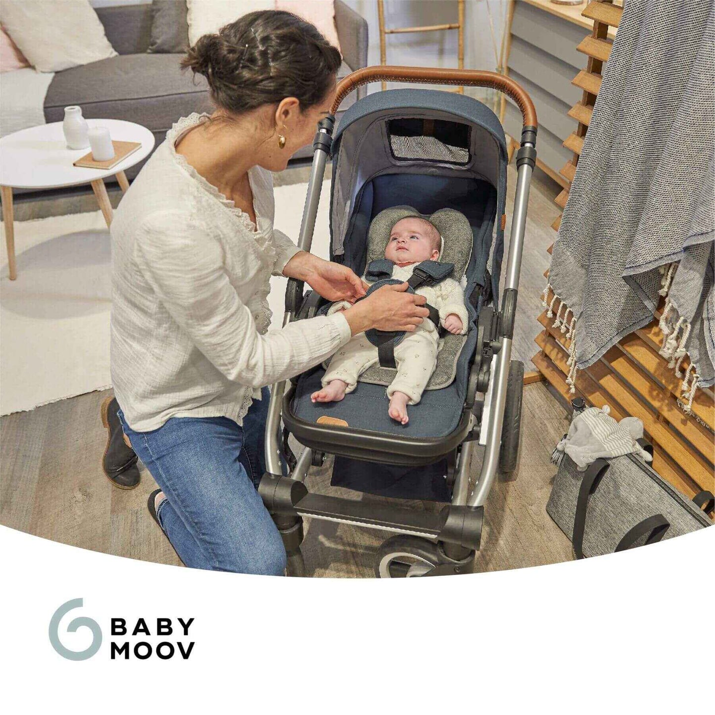 Woman adjusting a baby in a stroller with 'Baby Moov' branding.