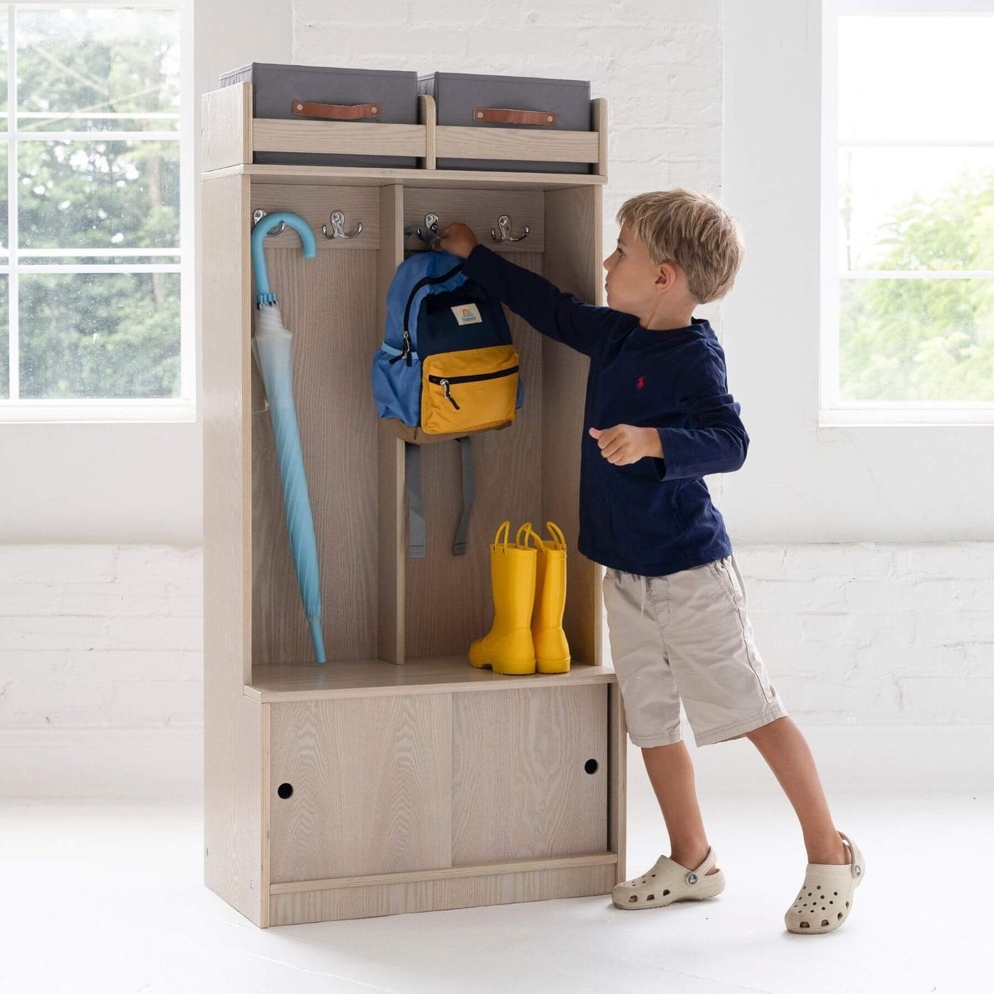 Boy Hanging Backpack in Little Partners Deluxe Cubby Ivory