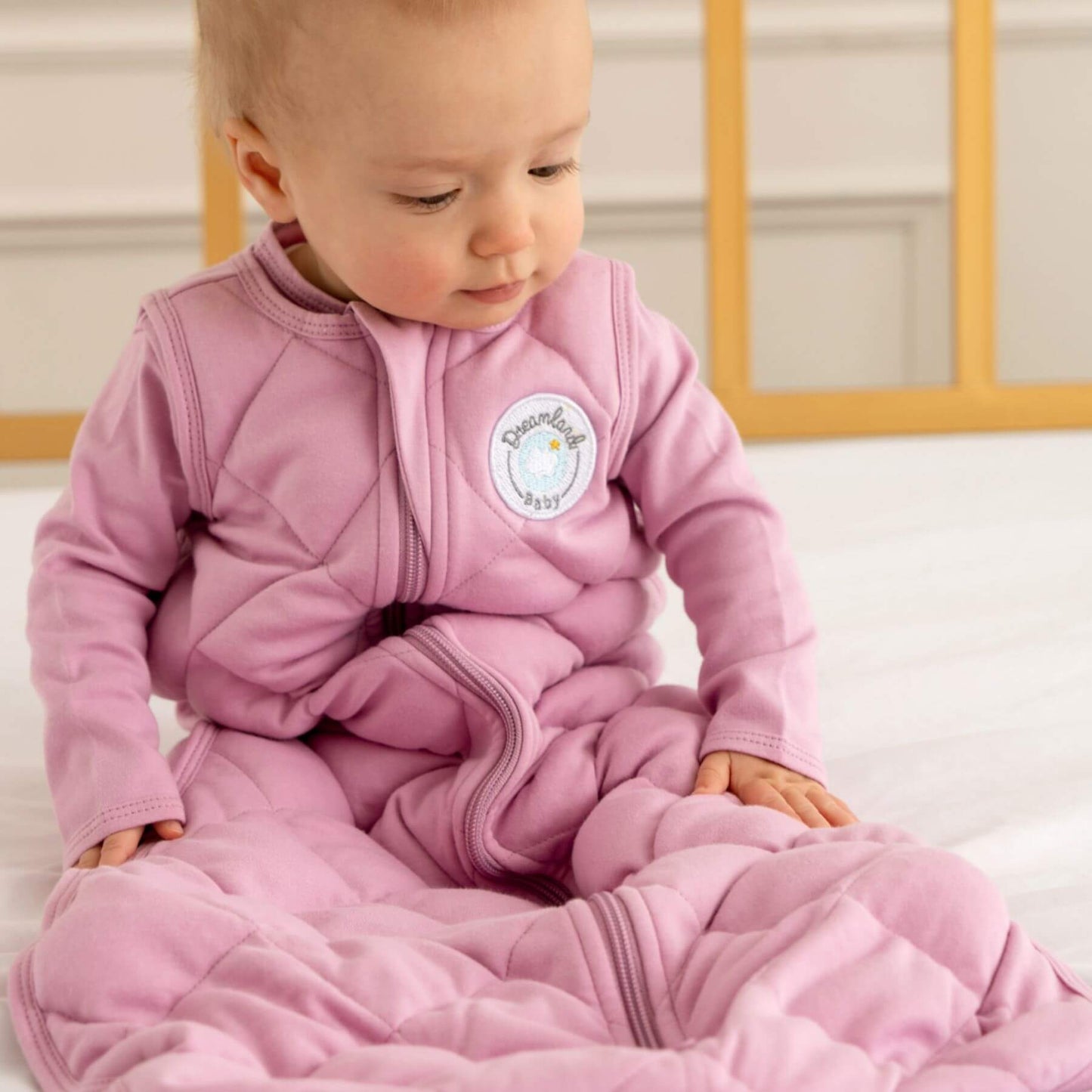 Baby in Dreamland Baby Dream Weighted Sleep Sack Misty Mauve, sitting on a white surface.
