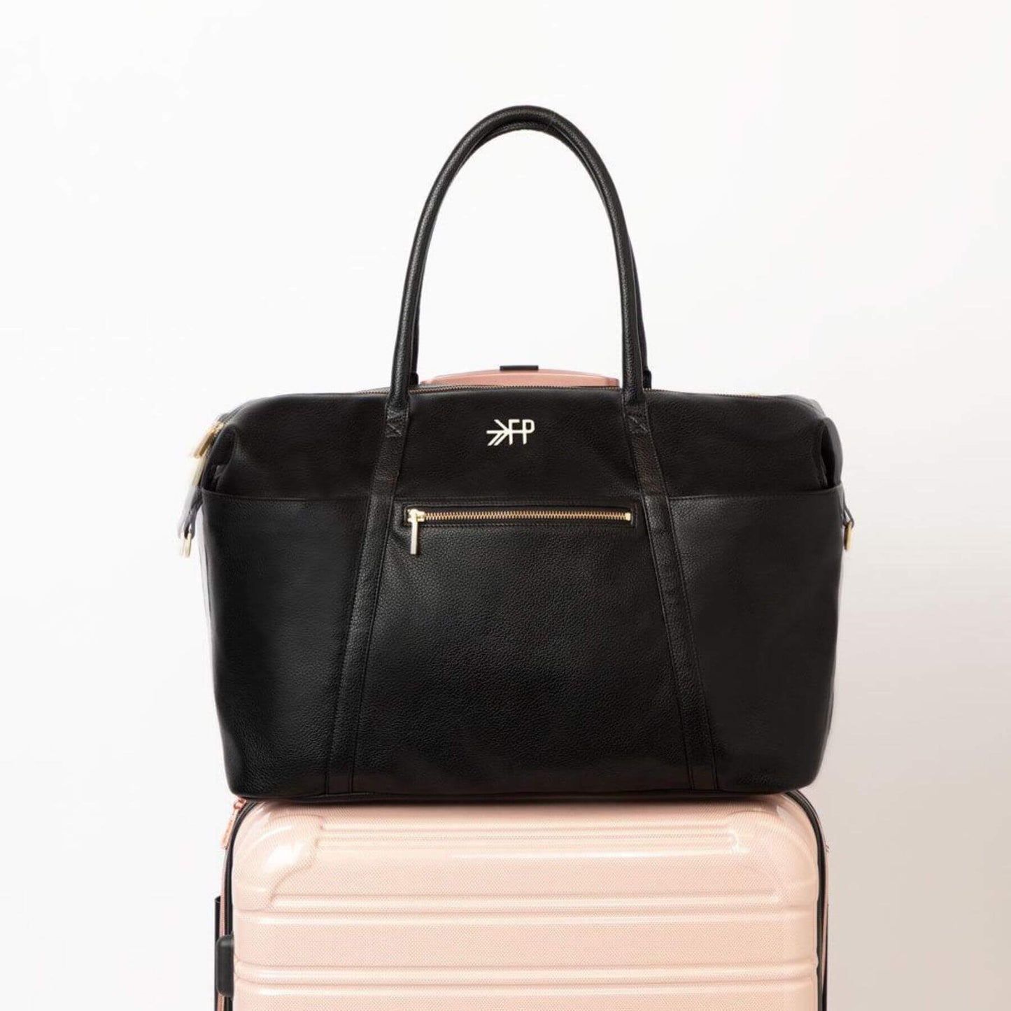 Ebony Classic Weekender on top of a pink suitcase