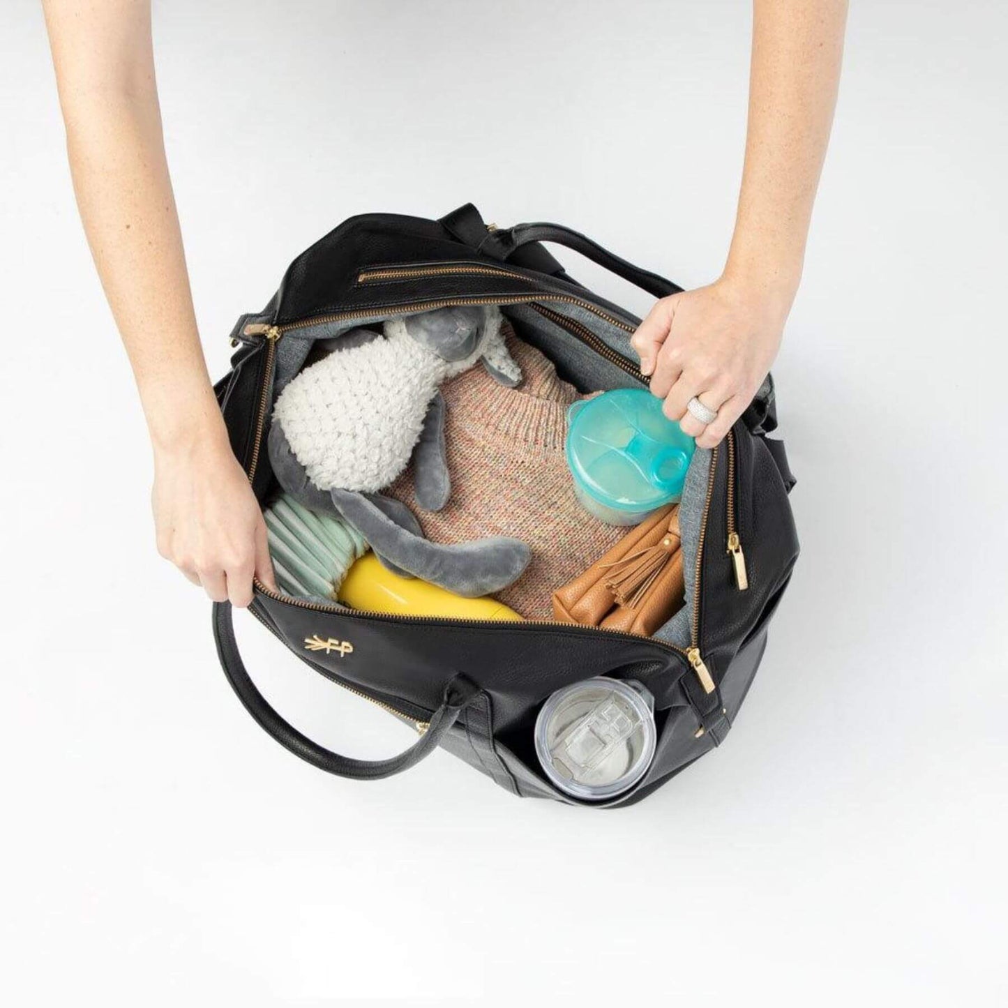Ebony Classic Weekender with baby items on a white background