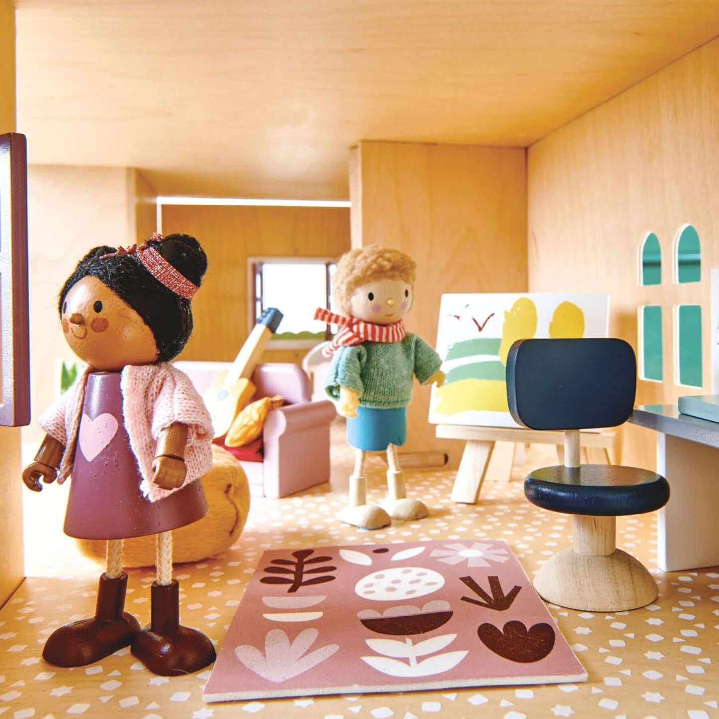 Toy dolls in a playroom setting with furniture and decor.
