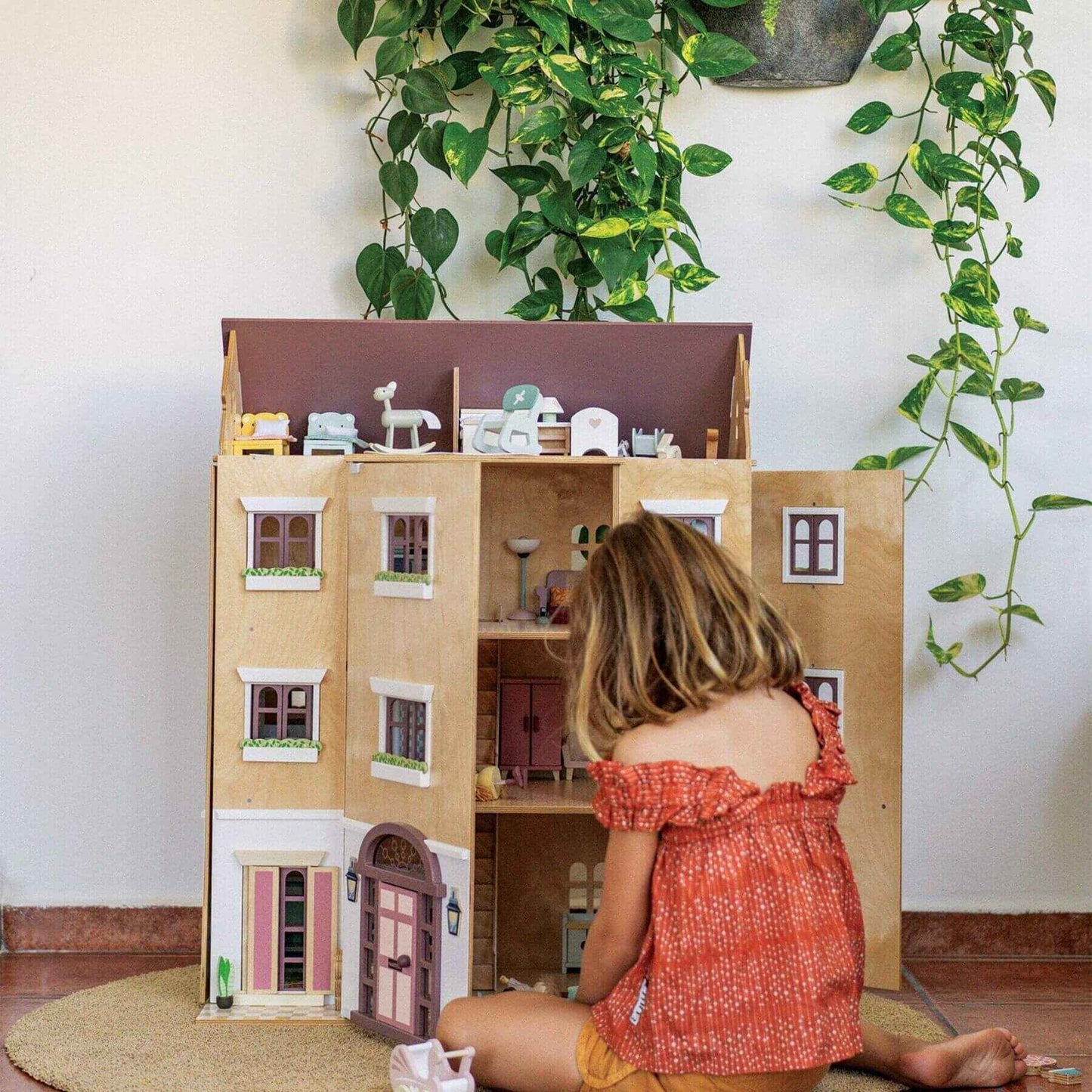 Child playing with Tender Leaf Fantail Hall in a room with plants.
