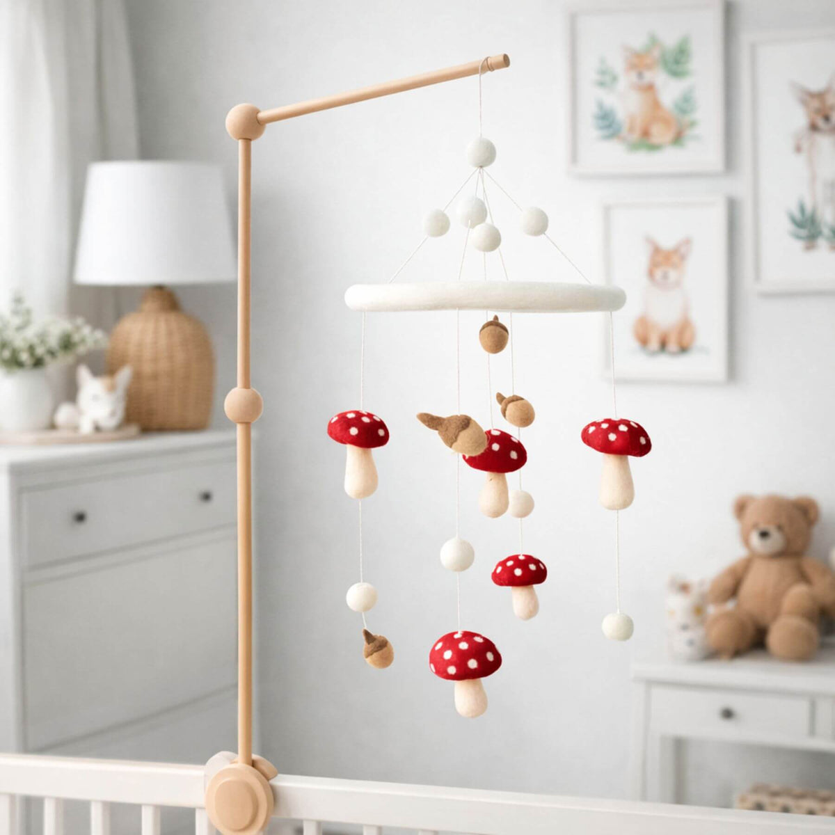 Wooden crib mobile with mushrooms hanging over a crib in a nursery.