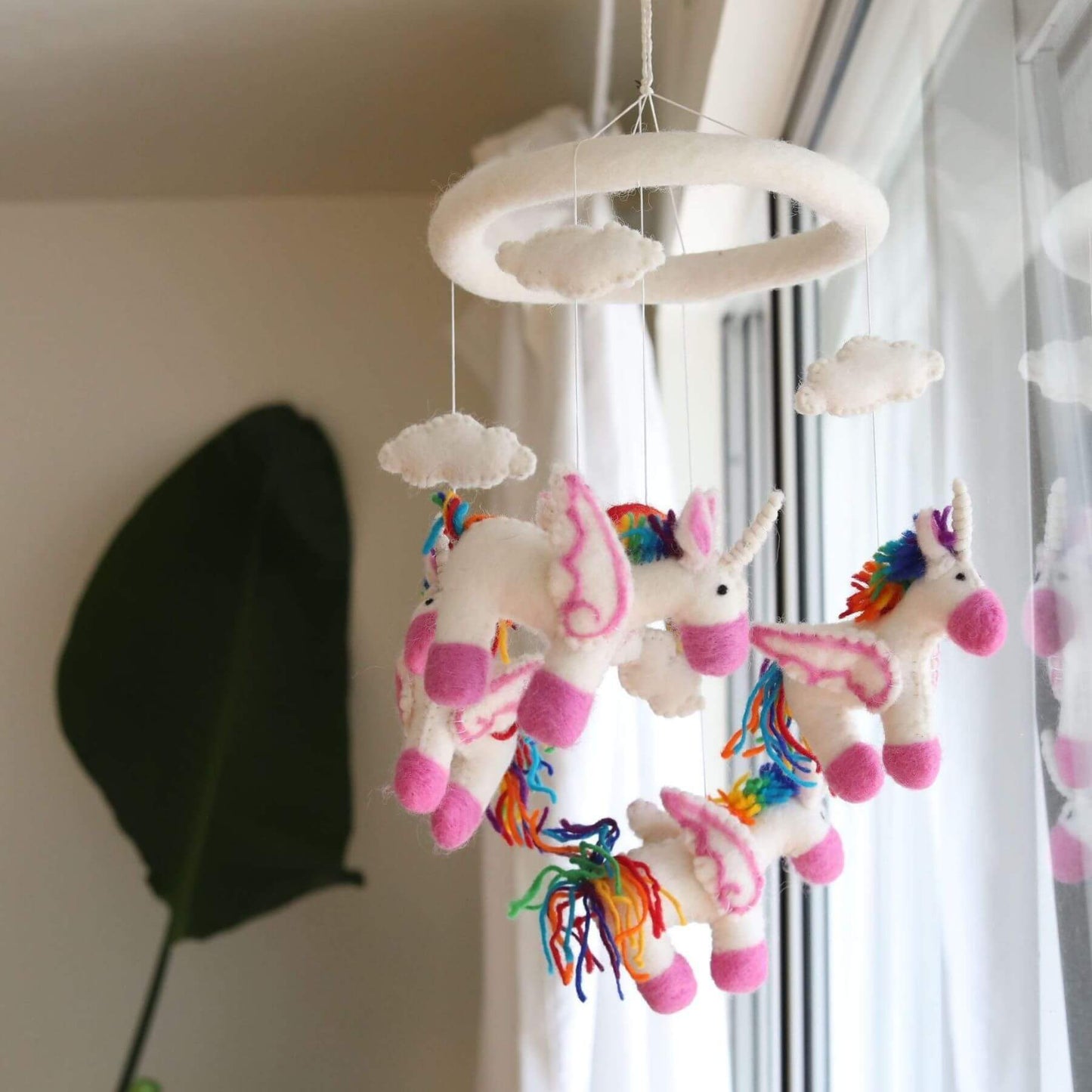 Ganapati Crafts Co. Felt Unicorn Baby Mobile hanging from a ceiling