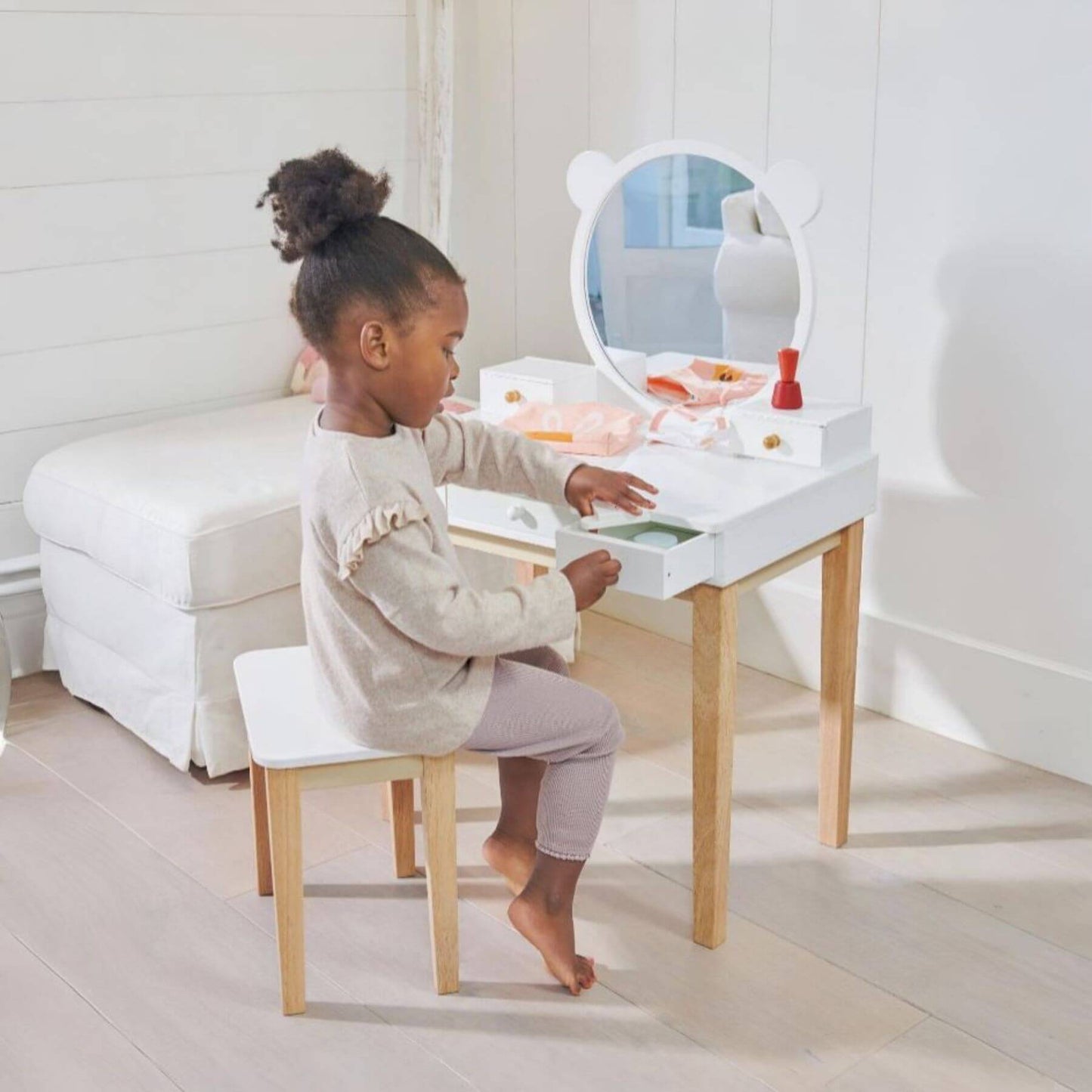 Child playing with Tender Leaf Forest Dressing Table in a bright room.