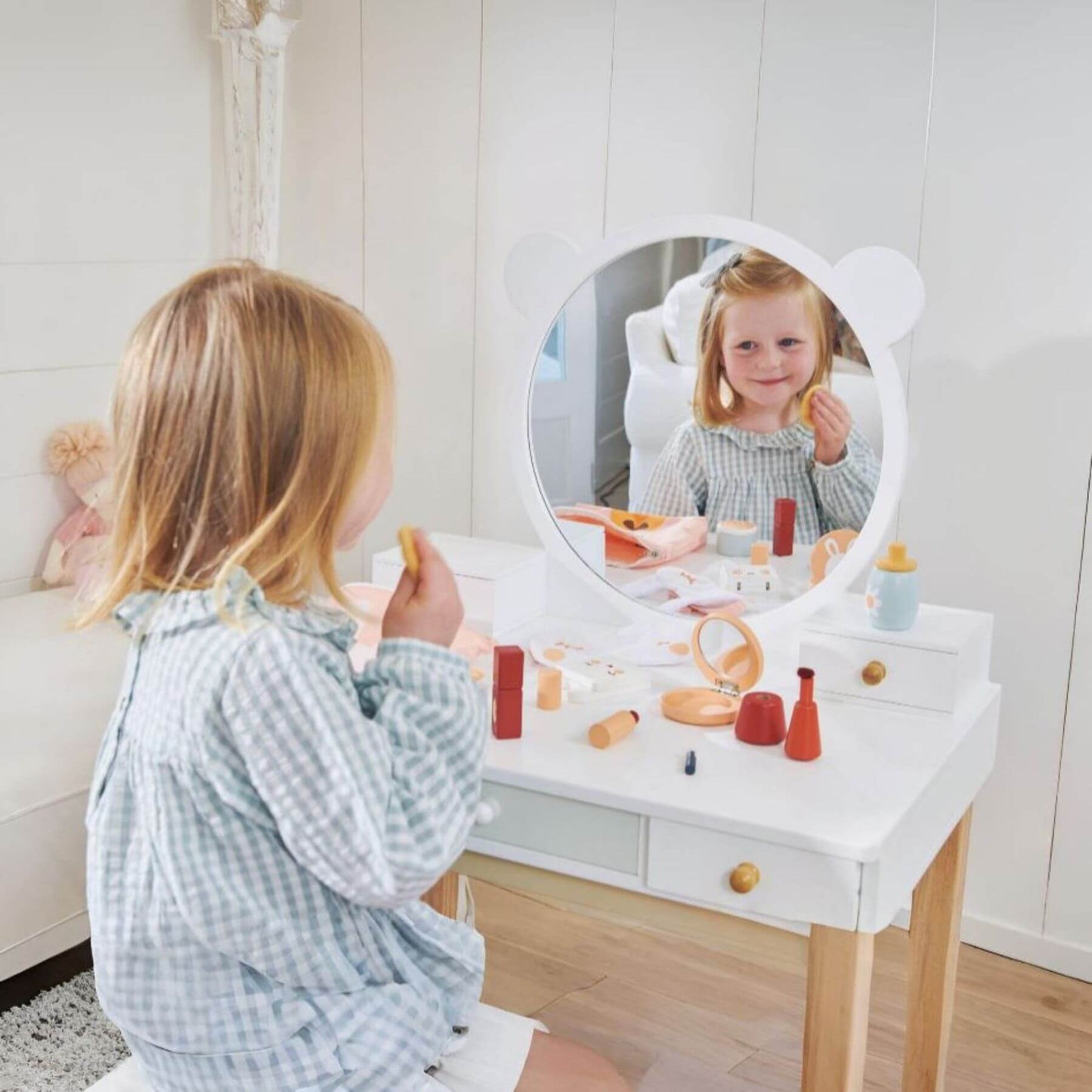 Child playing with Tender Leaf Forest Dressing Table in a room with a white wall.