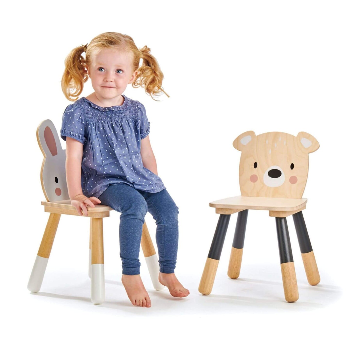 Child sitting on a rabbit chair next to bear chair on a white background