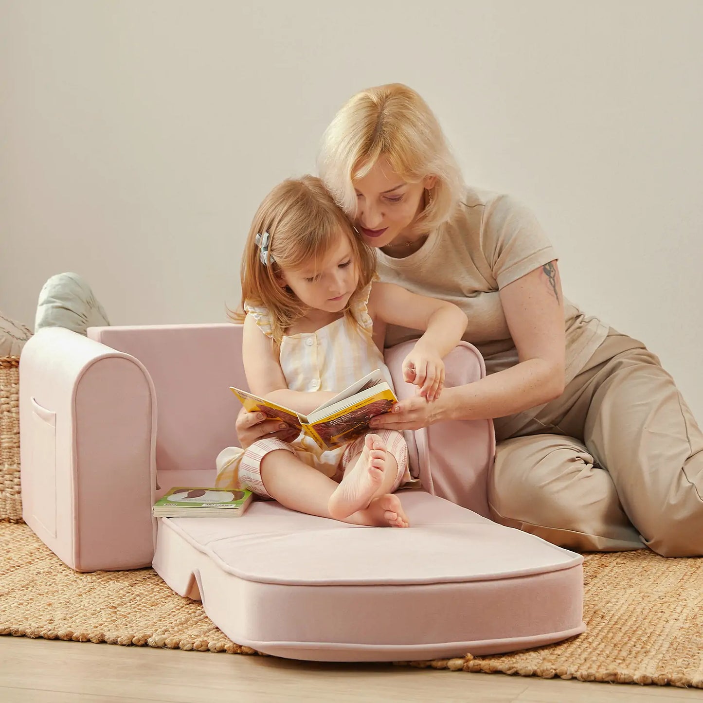 Woman and child reading a book on Tiny Land® GentleSnug Kid Chair Pink
