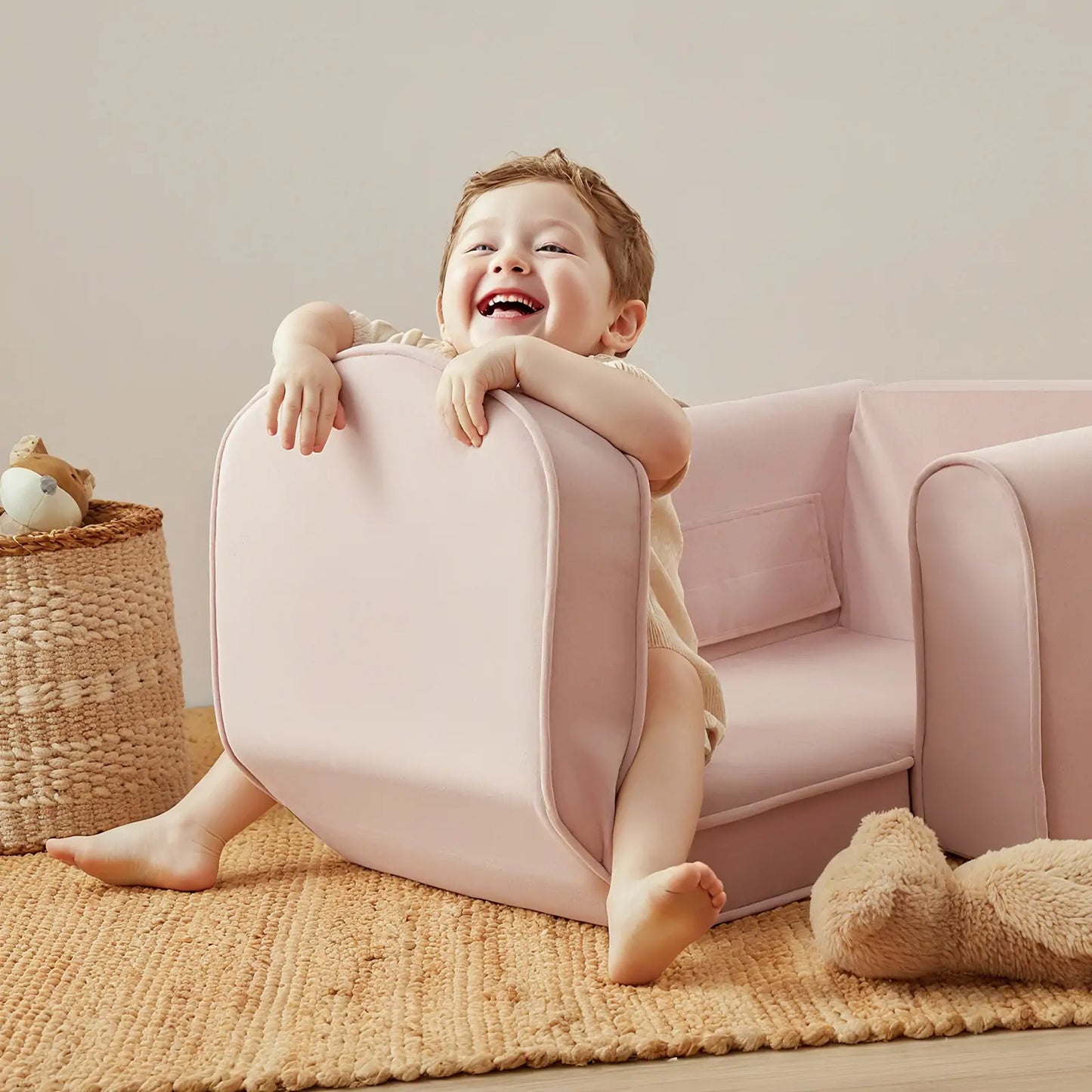 Child playing with Tiny Land® GentleSnug Kid Chair Pink in a cozy room