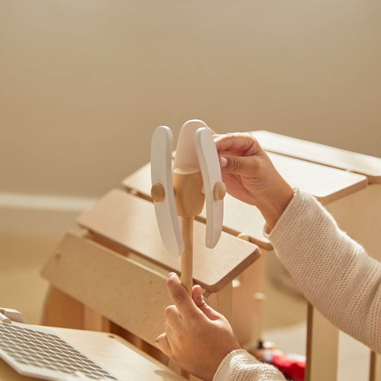 Person holding a wooden toy with a blurred background
