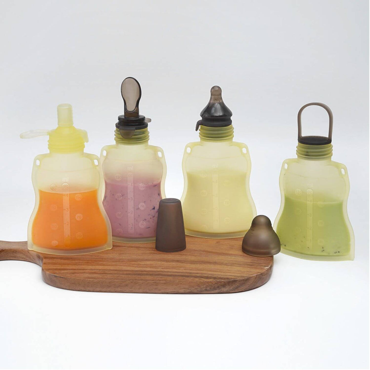 Set of four Haakaa Silicone Yummy Pouches with wooden holder on a white background