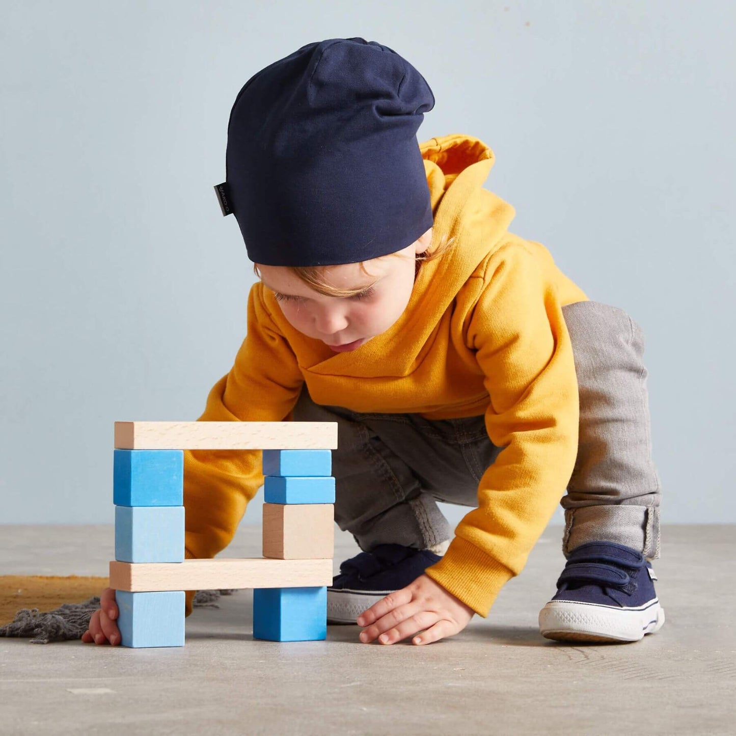Child playing with colorful blocks on a wooden floor