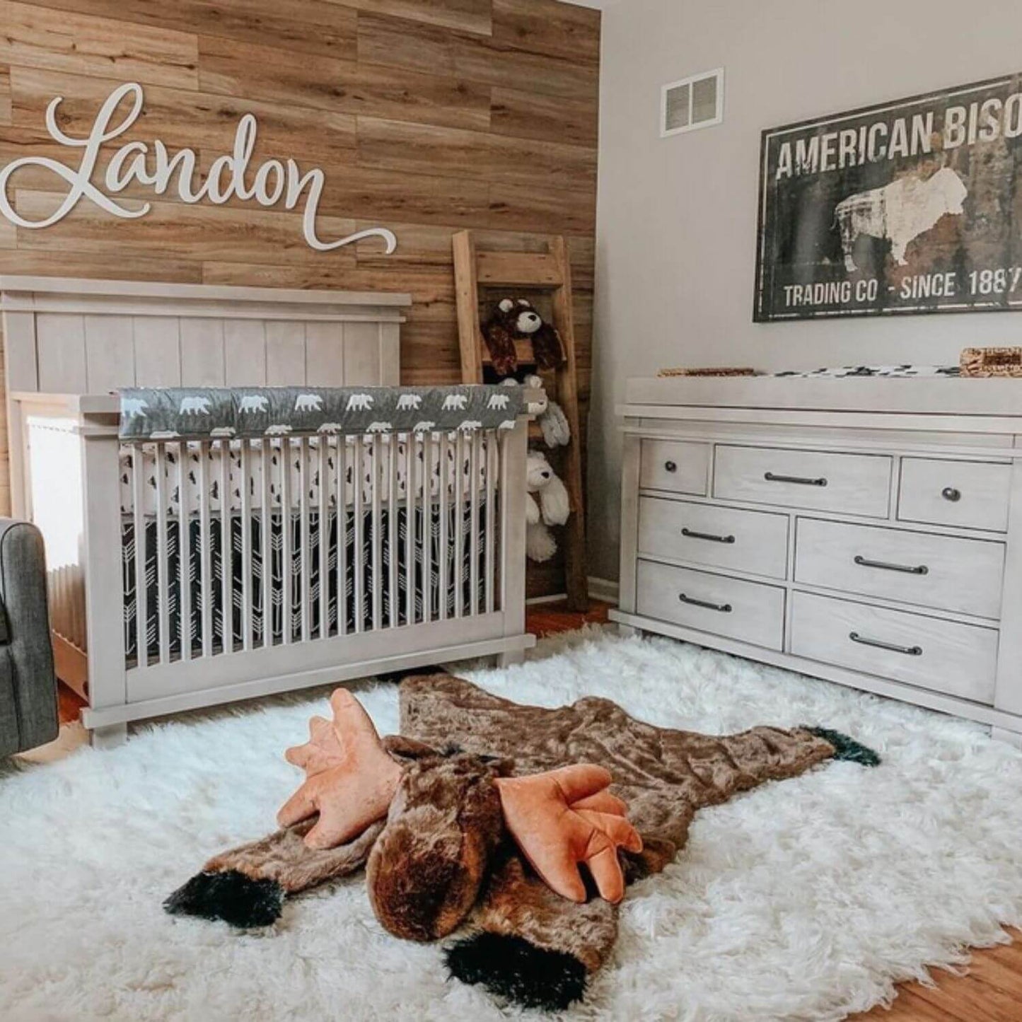 Nursery room with wooden wall, crib, and decorative elements.