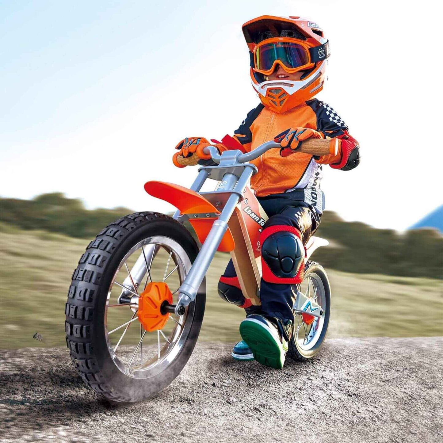 Child in motocross gear riding Hape Off Road Balance Bike outdoors