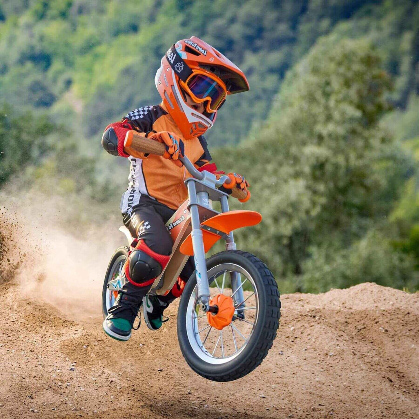 Child riding Hape Off Road Balance Bike on a dirt trail with a helmet and protective gear.