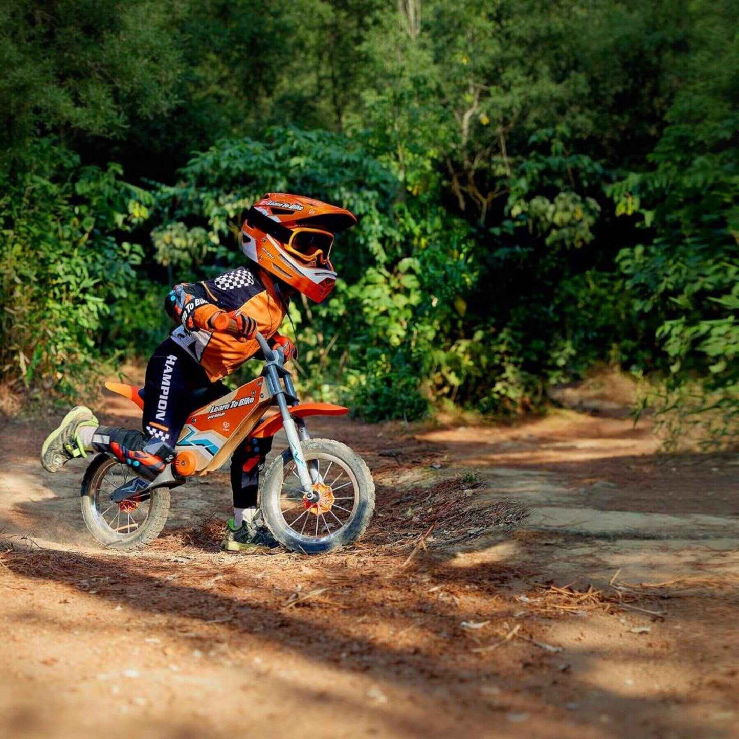 Child riding Hape Off Road Balance Bike on a dirt path with greenery in the background