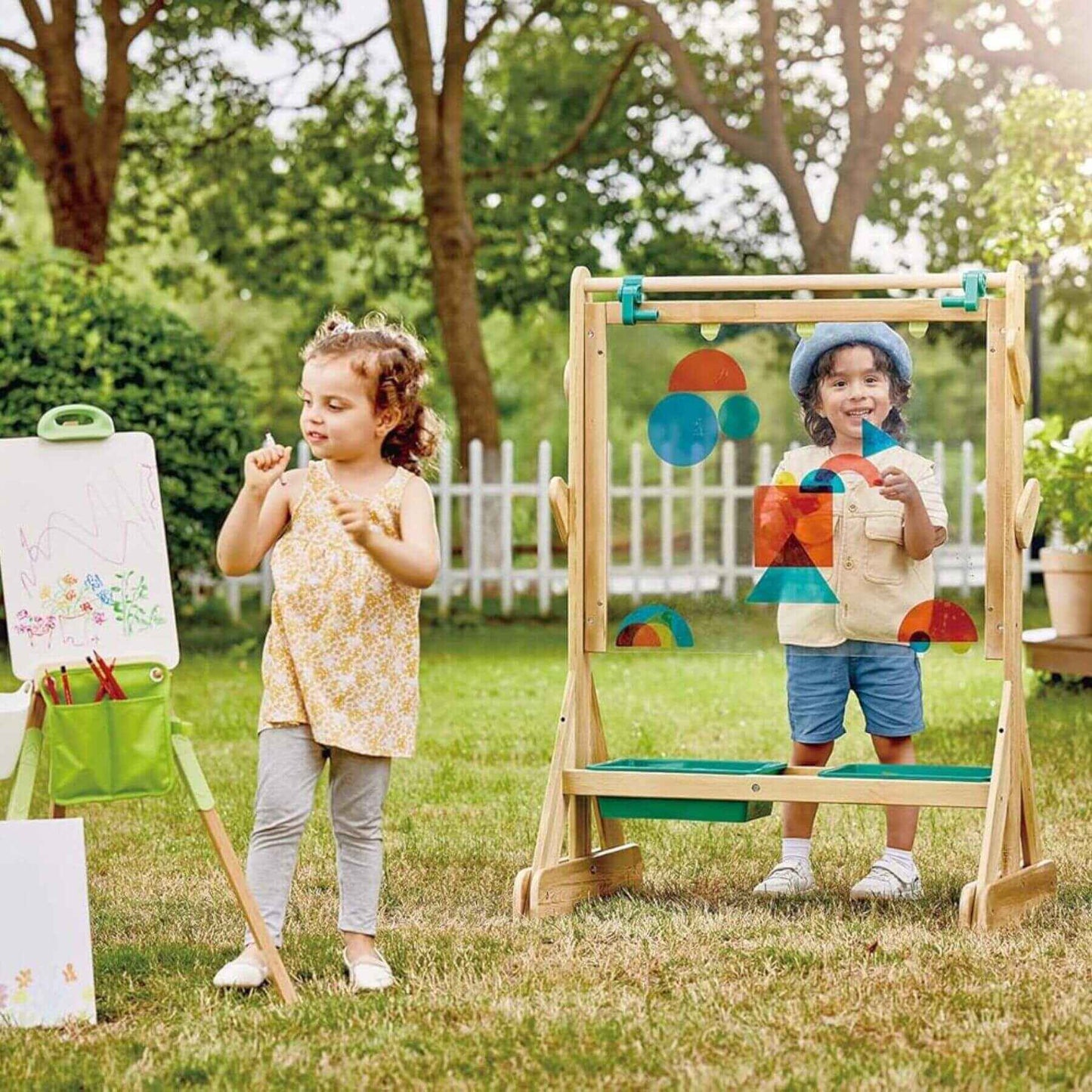 Two children playing outdoors with Hape Outdoor Art Easel.