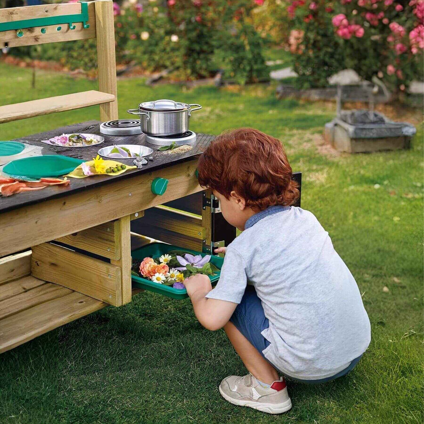 Boy Playing Hape Outdoor Kitchen