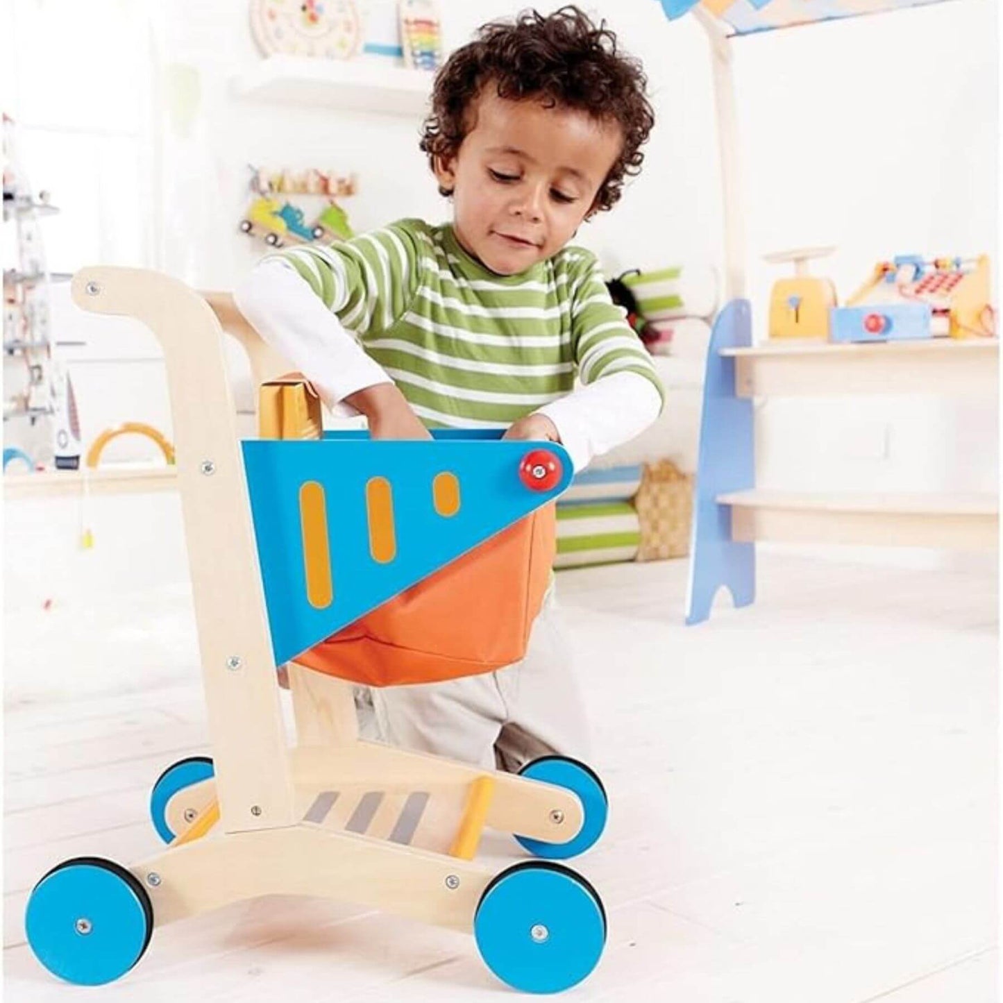 Child playing with Hape Shopping Cart in a colorful room