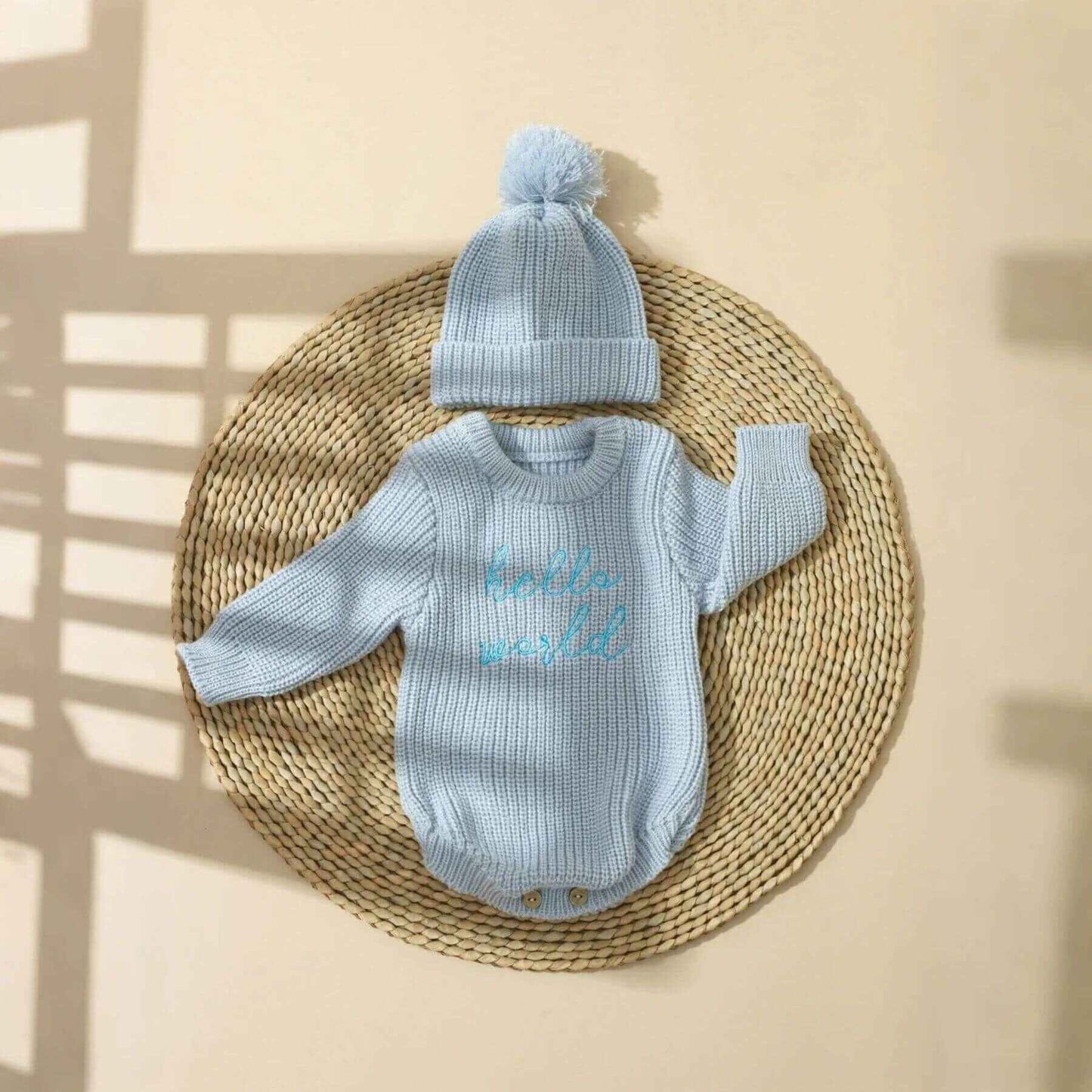 Newborn Hello World Knitted Bodysuit Set Blue on a woven mat
