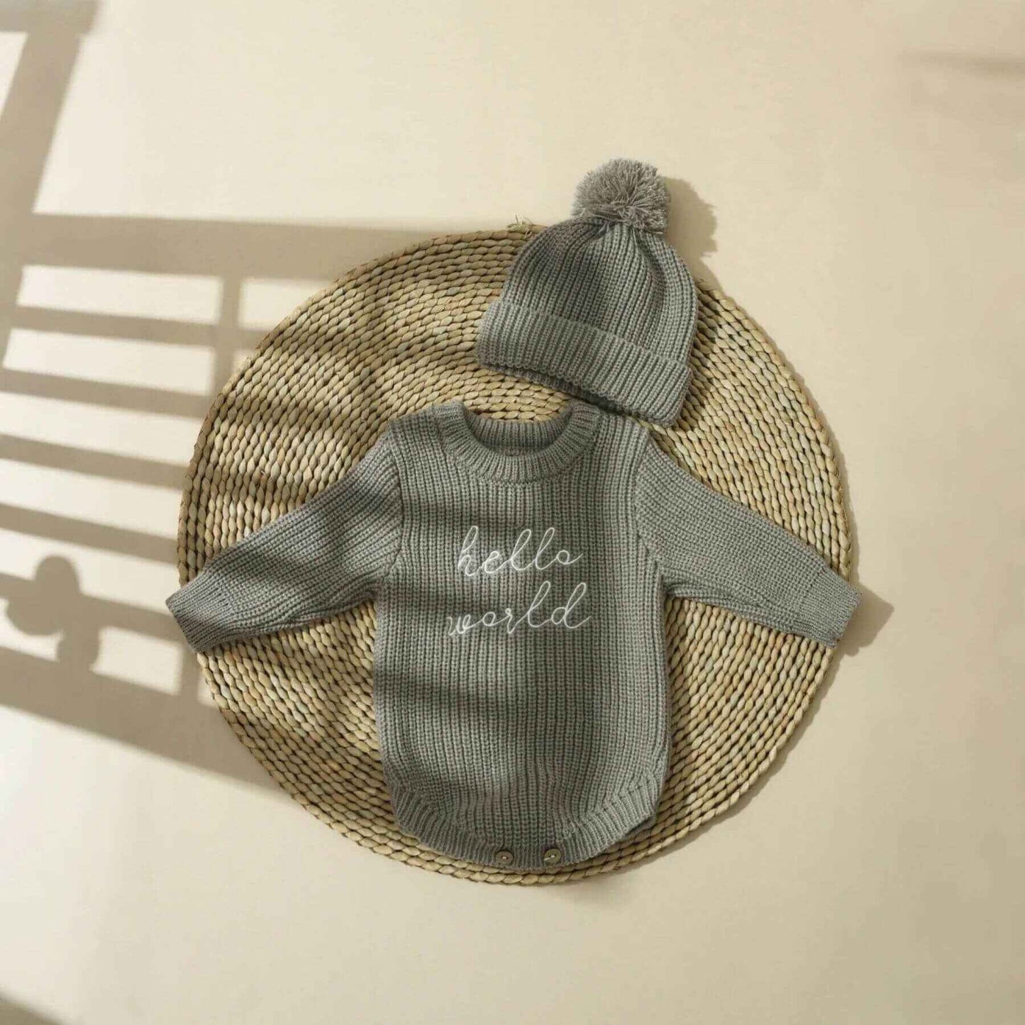 Newborn Hello World Knitted Bodysuit Set Grey on a woven mat